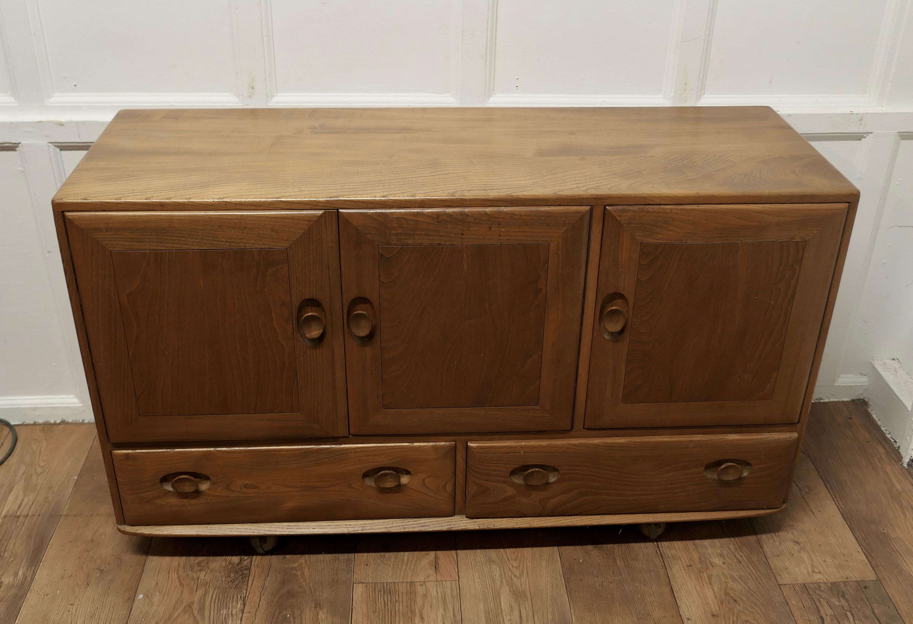 Mid-Century Modern A Mid Century Golden Elm Sideboard by Ercol  The sideboard has 3 cupboard doors 