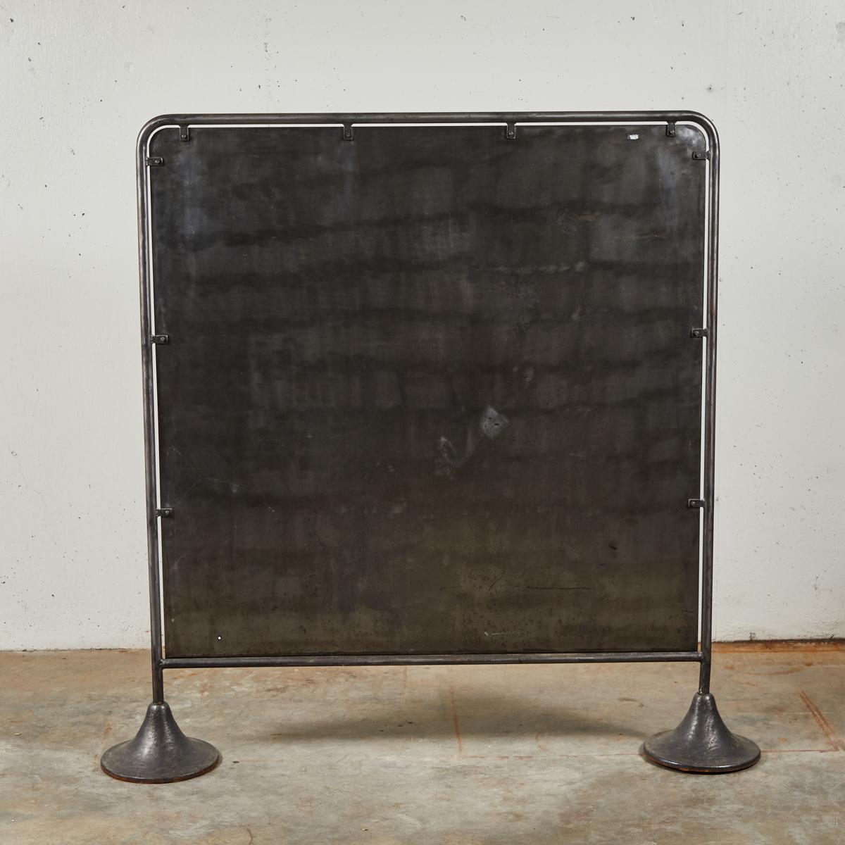 French mid-century burnished metal screen, for use as a spatial divider or head-board. With modernist bell-shaped feet, clean lines, and a steely metallic finish, the piece has a swank, industrial air. Two available.

France, circa 1950

Dimensions: