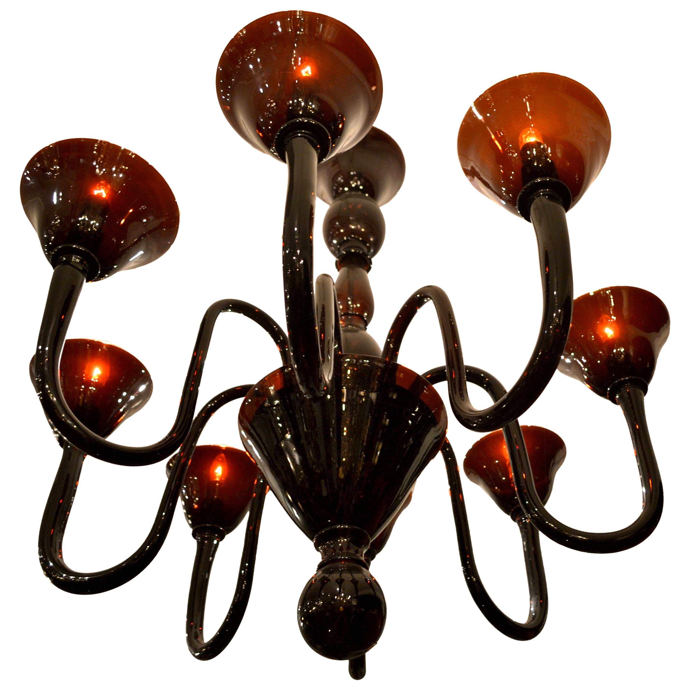 A Classic chandelier from Murano, Italy featuring eight hand blown arms and ‘shades’ connected to a central blown glass stem, the wiring concealed by a gilded metal internal bowl cased in a blown glass ‘shade’ with a suspended glass