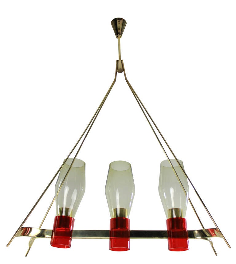 An Italian hanging light of unusual design, in brass with red detailing and pale yellow glass shades.

