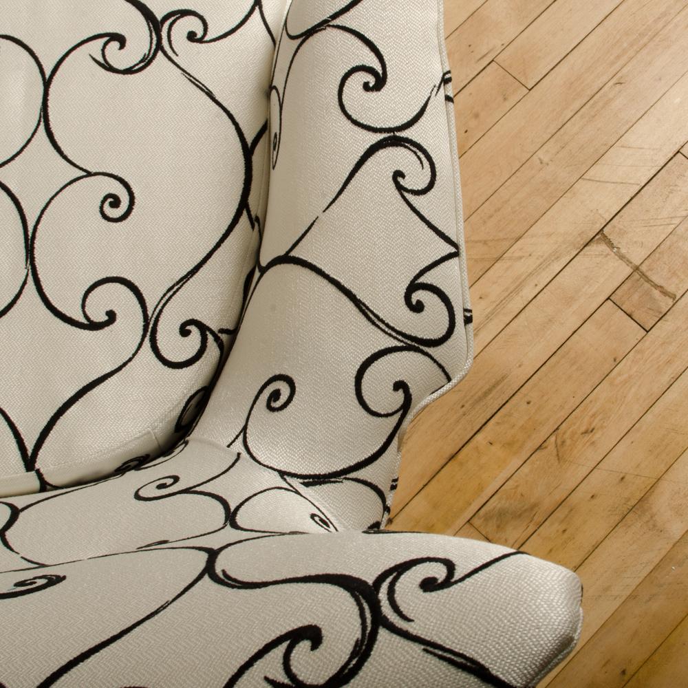 Ein elegantes und anmutiges italienisches schwarz-weiß gepolstertes Sofa mit geflügelter Rückenlehne, das Paolo Buffa zugeschrieben wird, um 1950. Kürzlich neu gepolstert.