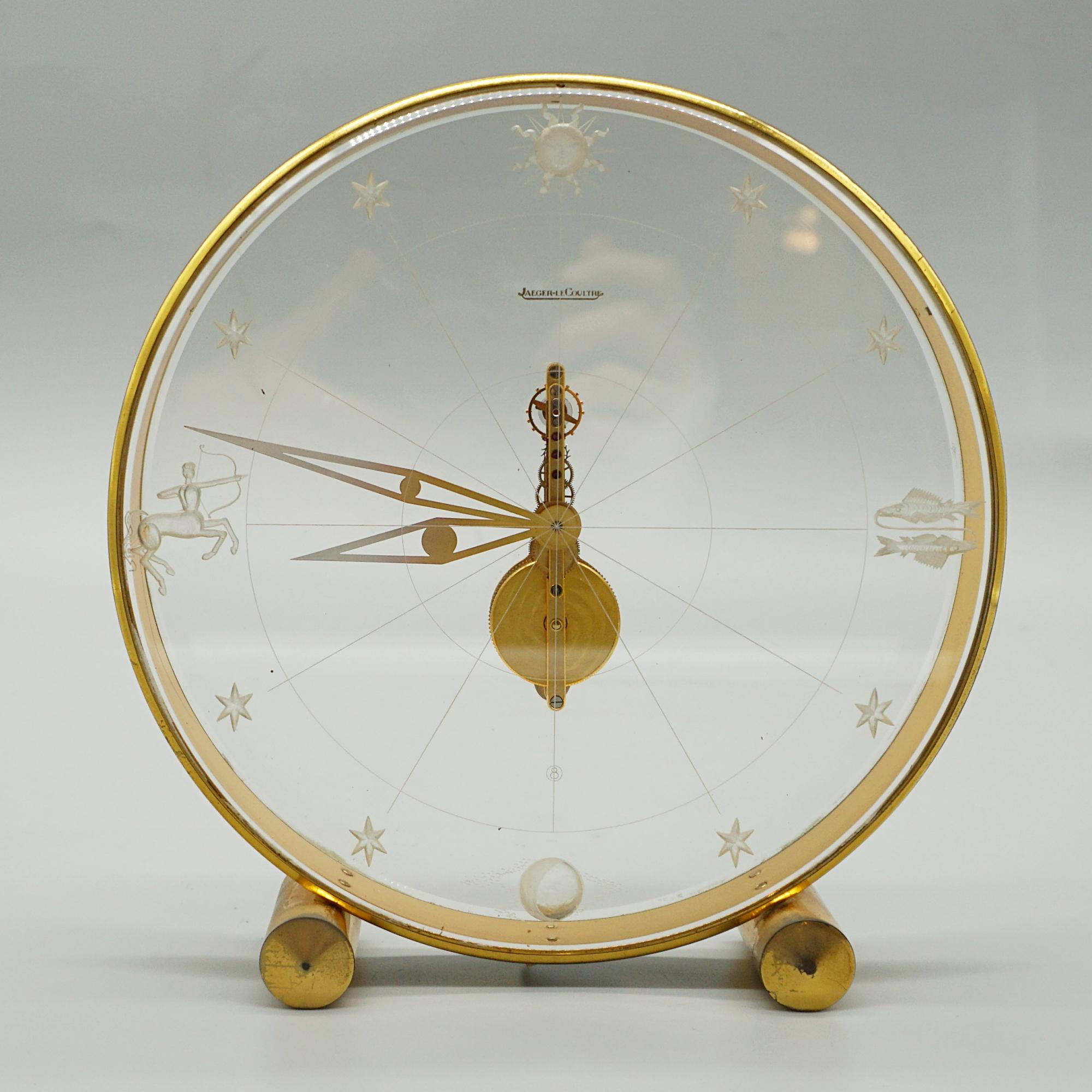 A Mid-Century Zodiac mantel clock by Jaeger LeCoultre. Circular lucite case with original brass hands and inset zodiac decoration. Set over a gilded brass base with rounded feet. 'JAEGER-LECOULTRE' etched to cock face. Original 8 day movement, in