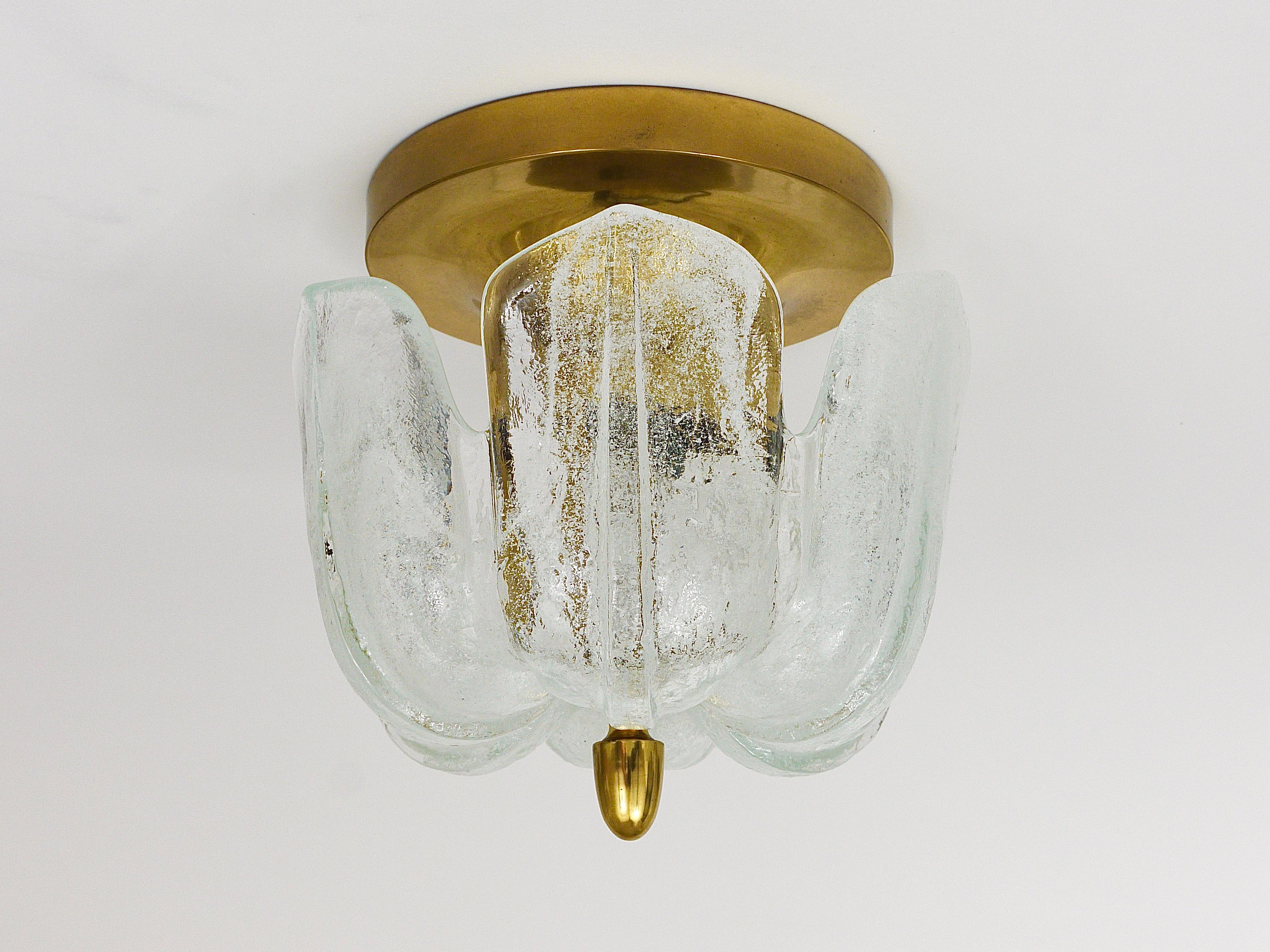 A beautiful petite ceiling light or flush mount from the 1970s, executed by Limburg, Germany. It has a brass base, one light source and a beautiful round melting glass or ice glass lampshade. In good condition with patina on the brass.
 