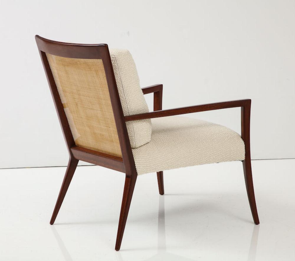 Una straordinaria poltrona da salotto della metà del secolo scorso realizzata in mogano massiccio e ricco, con lo schienale originale in canna intrecciata a mano. La struttura presenta linee pulite e scultoree tipiche dell'epoca, con gambe