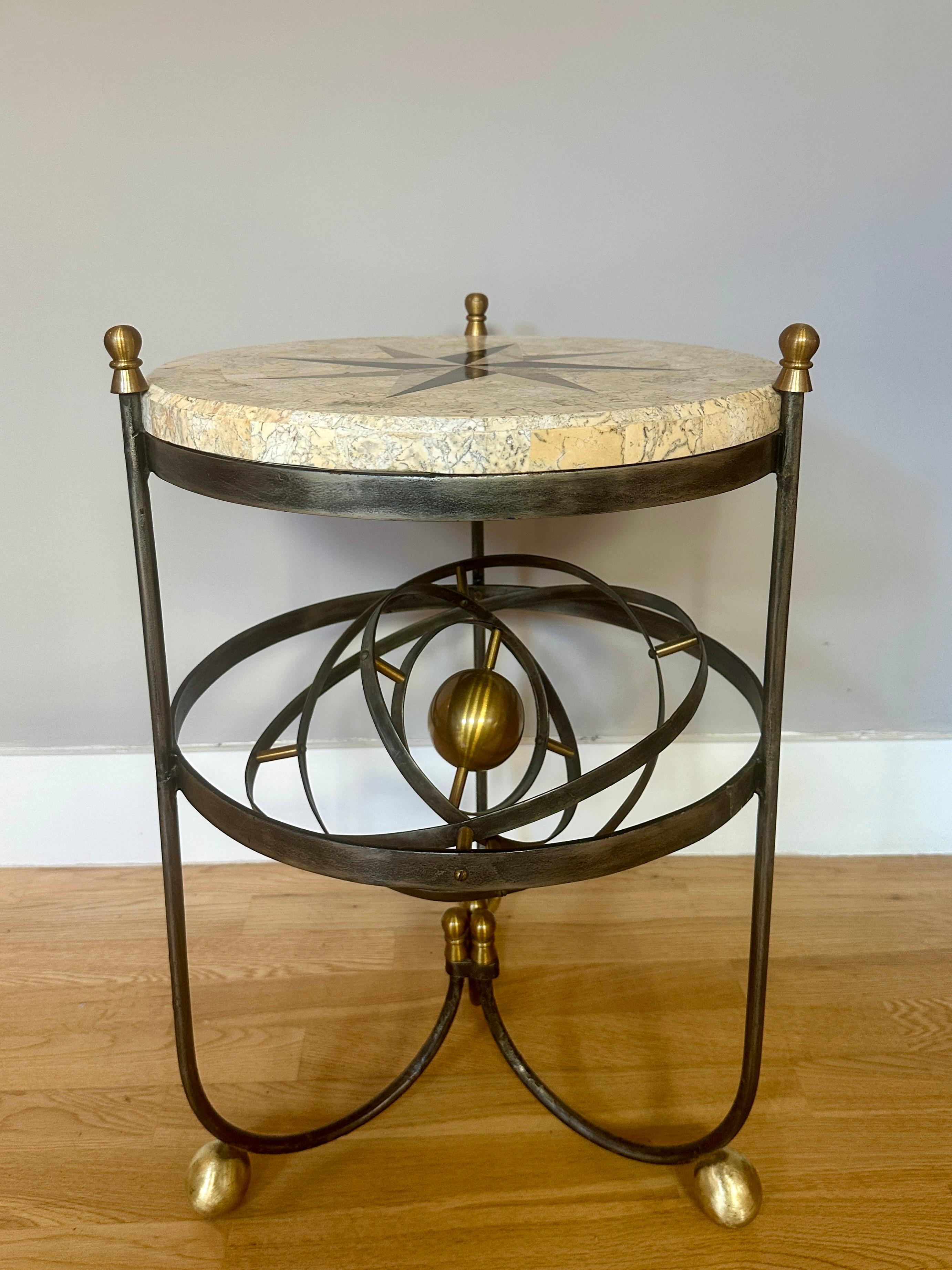 Mesa armilar continental con tablero de mármol con incrustaciones de una estrella de ocho puntas. Base de hierro forjado con remates de latón  y pies con una esfera armilar de latón totalmente funcional en su interior. 