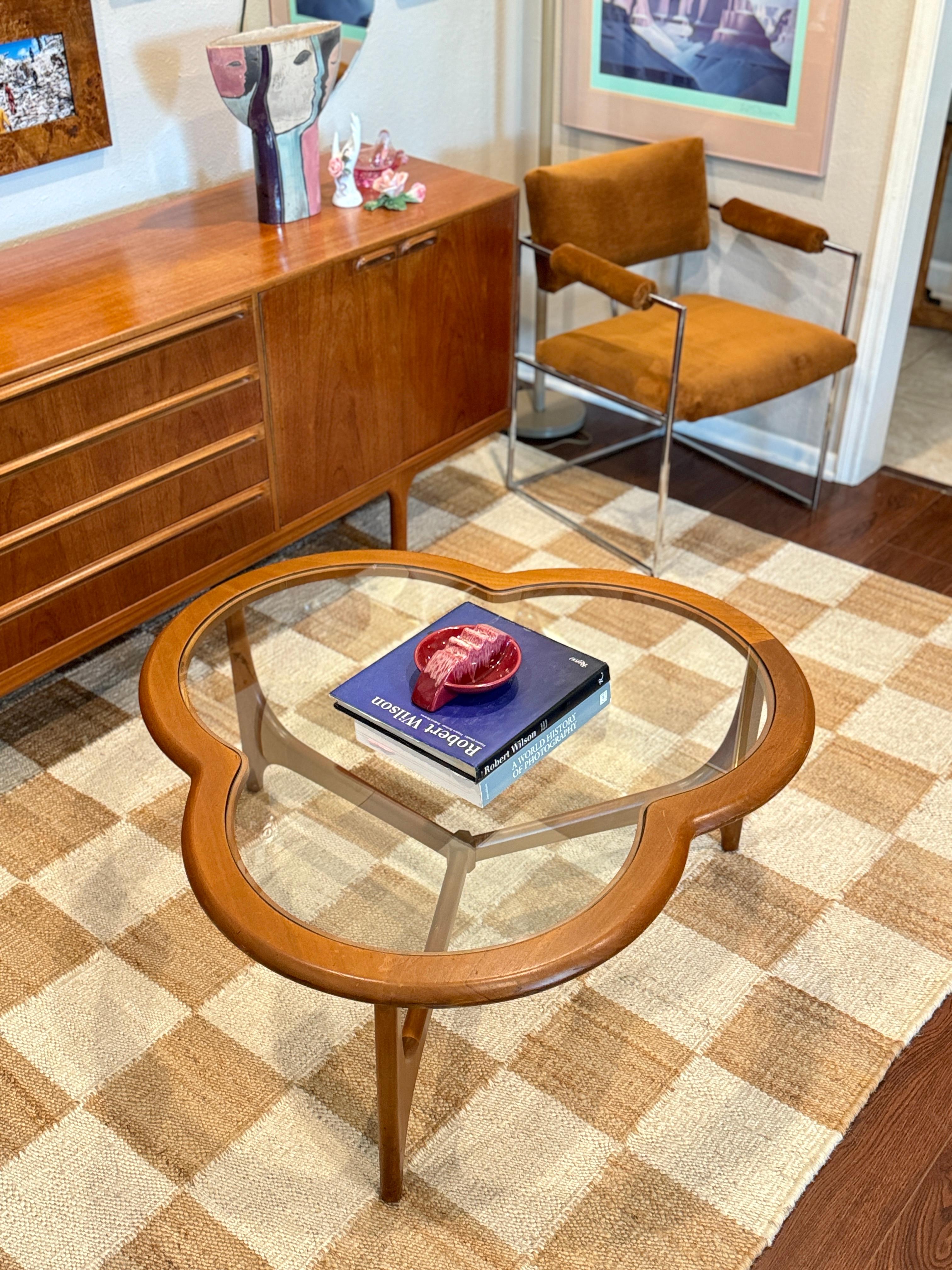 A unique mid century modern 3 leaf clover coffee table from the Stonehill Stateroom range, circa 1970s. This beautiful coffee table features an inset shaped glass top, sculptural three leg stretcher base, solid walnut frame, and great overall form.