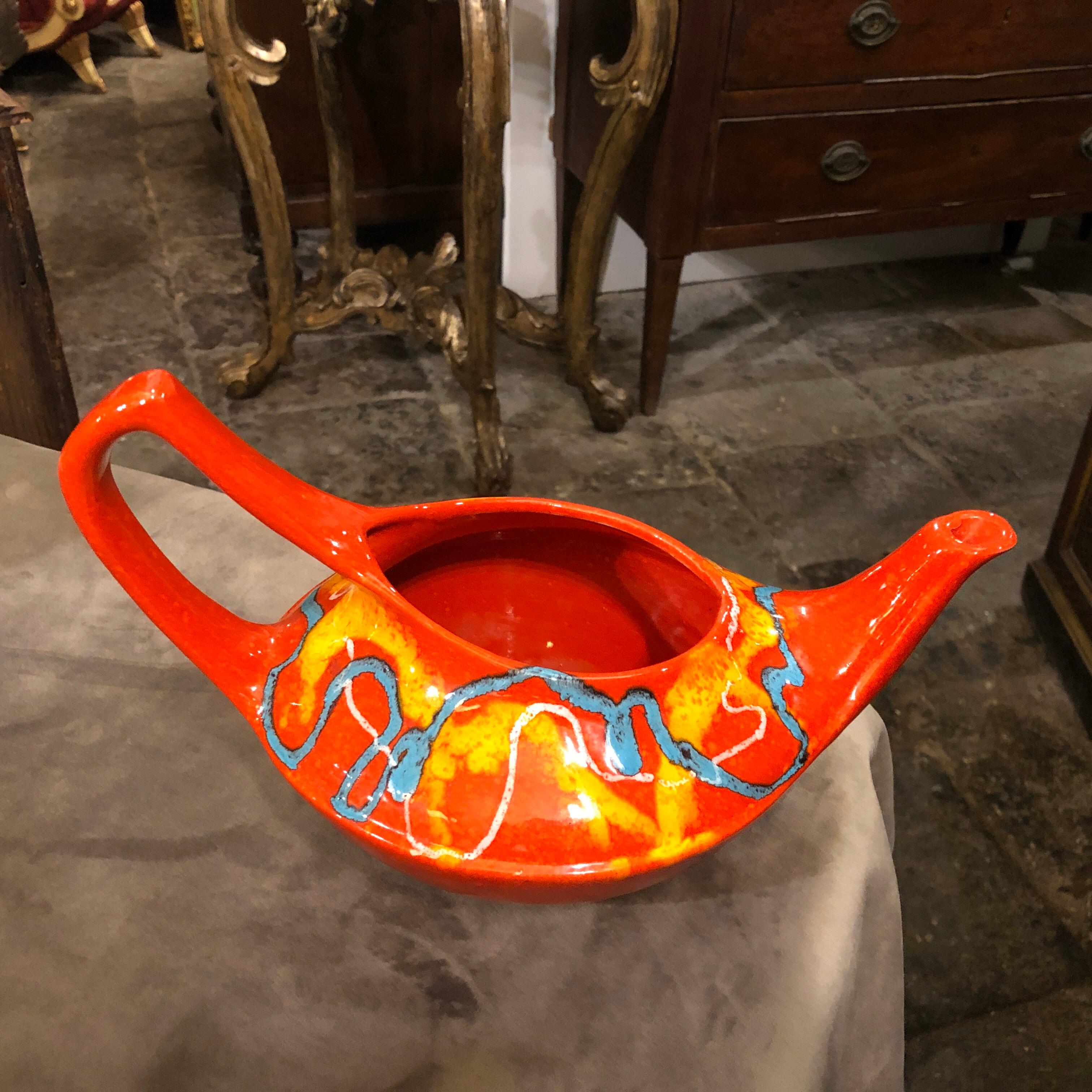 A red blue and yellow ceramic pitcher designed and manufactured in Italy by Bertoncello in the 1970s. Good conditions overall. The Bertoncello pottery company was founded in 1909 in Italy and gained recognition for its ceramics during the mid-20th