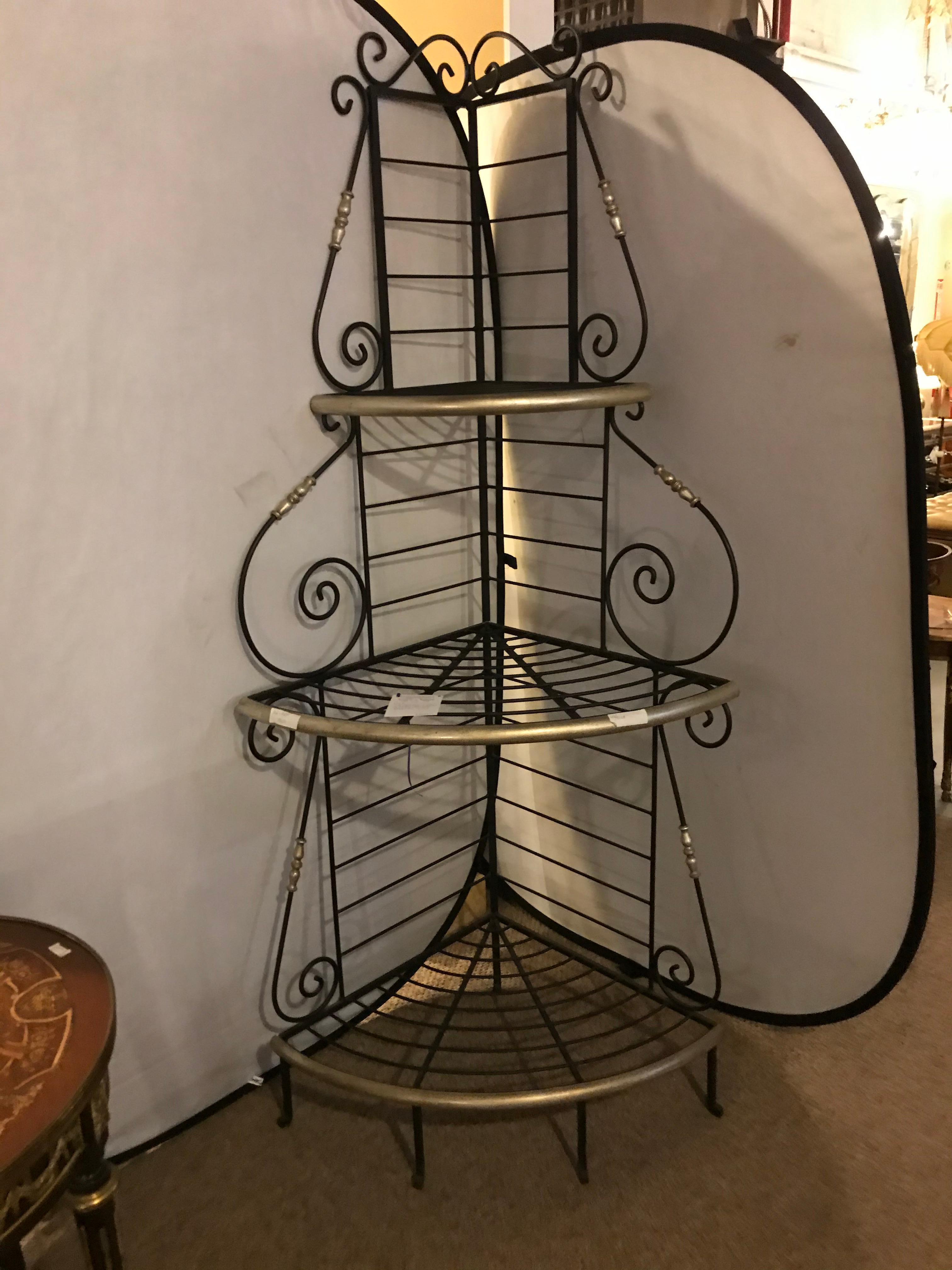 A Mid-Century Modern brass and iron 3-tier corner bakers rack. Having an ebony iron scroll back design with brass framing and design.