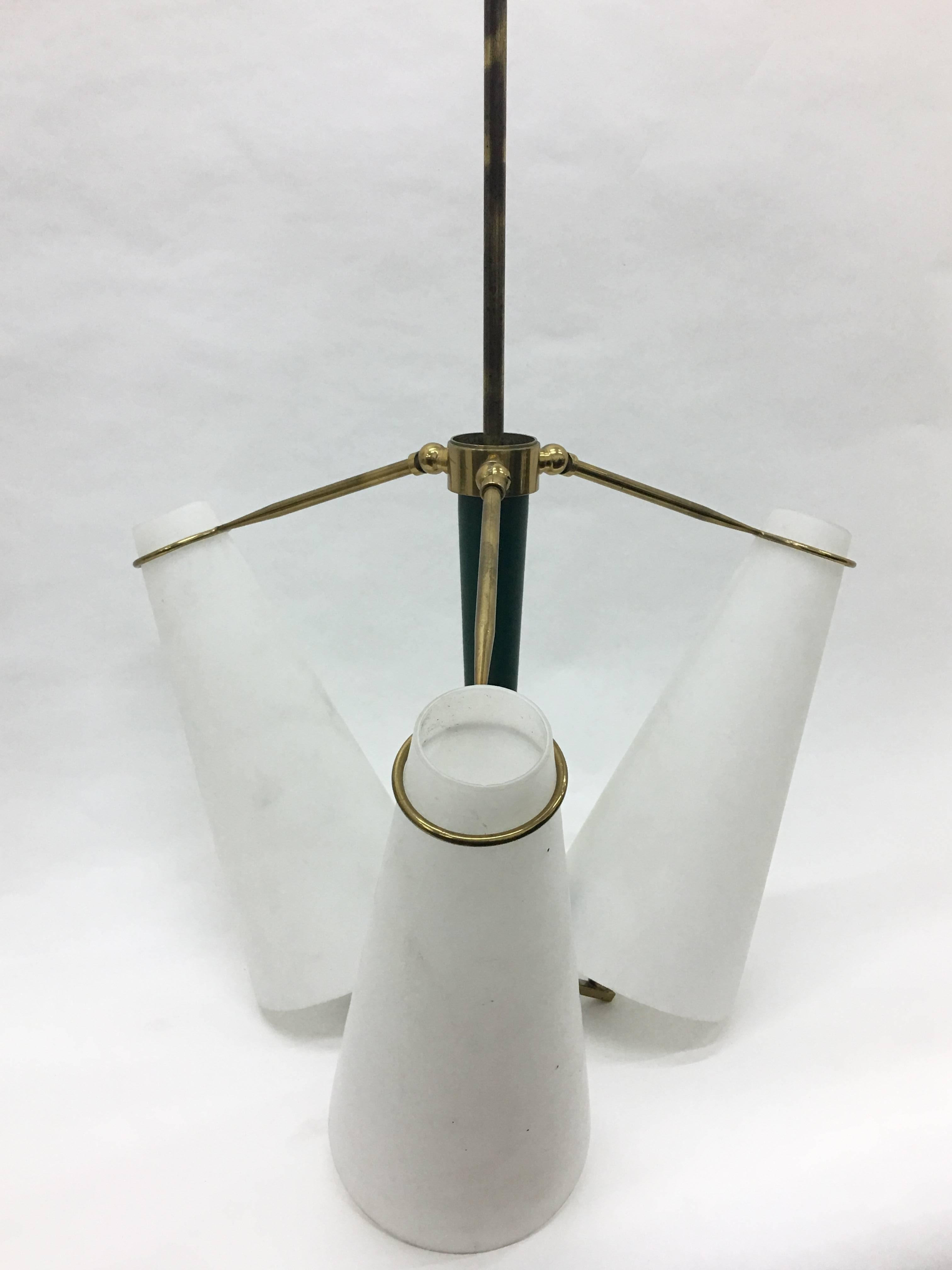 Three-light chandelier in the style of Stilnovo with articulated brass arms, green metal central part and white glasses. Fully restored electrical parts. It works with both 110 and 220 Volt and needs regular e14 bulbs