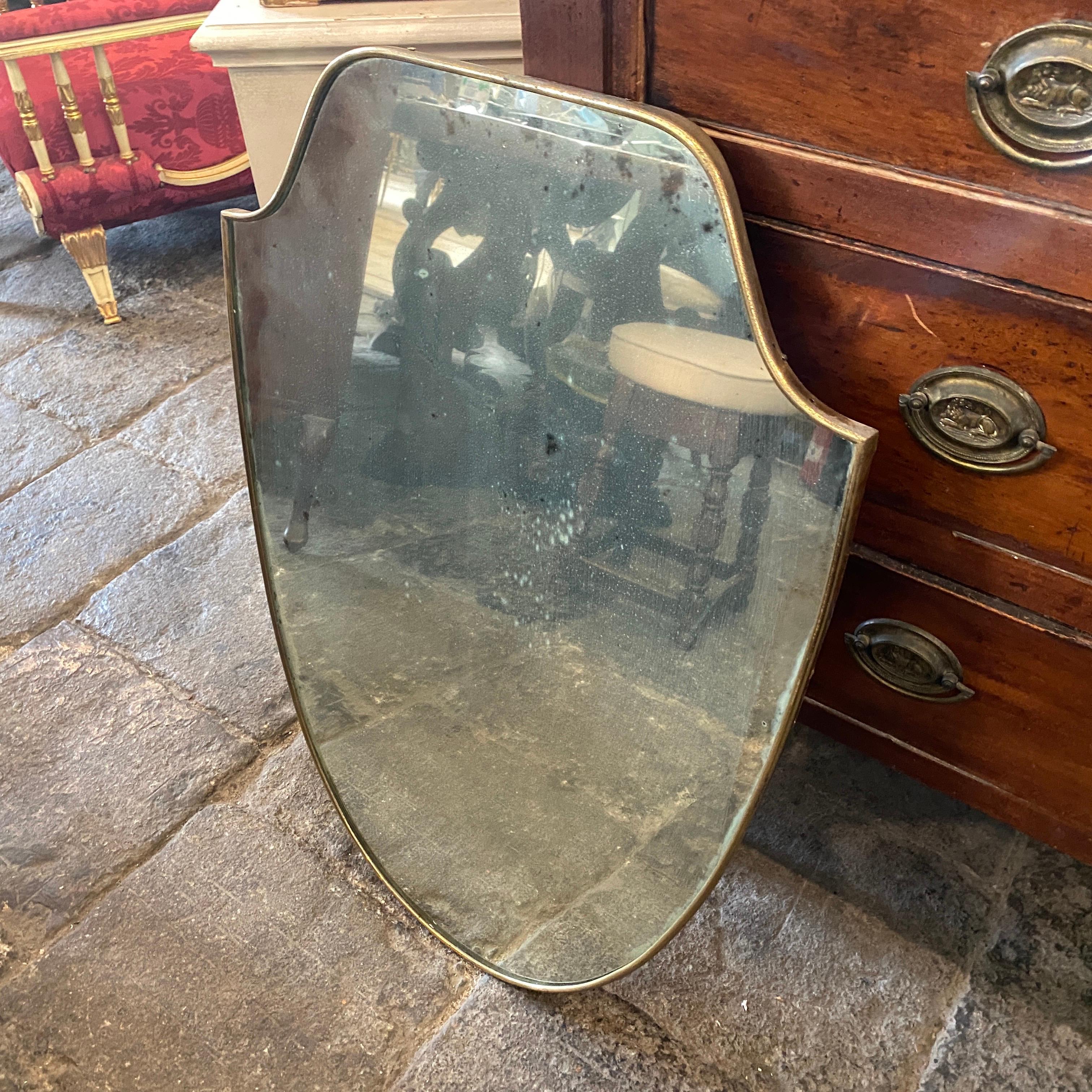 A shield wall mirror made in Italy in the 1950s, solid brass has original patina. Please check all the photos, mirror has an opacity due to the time.