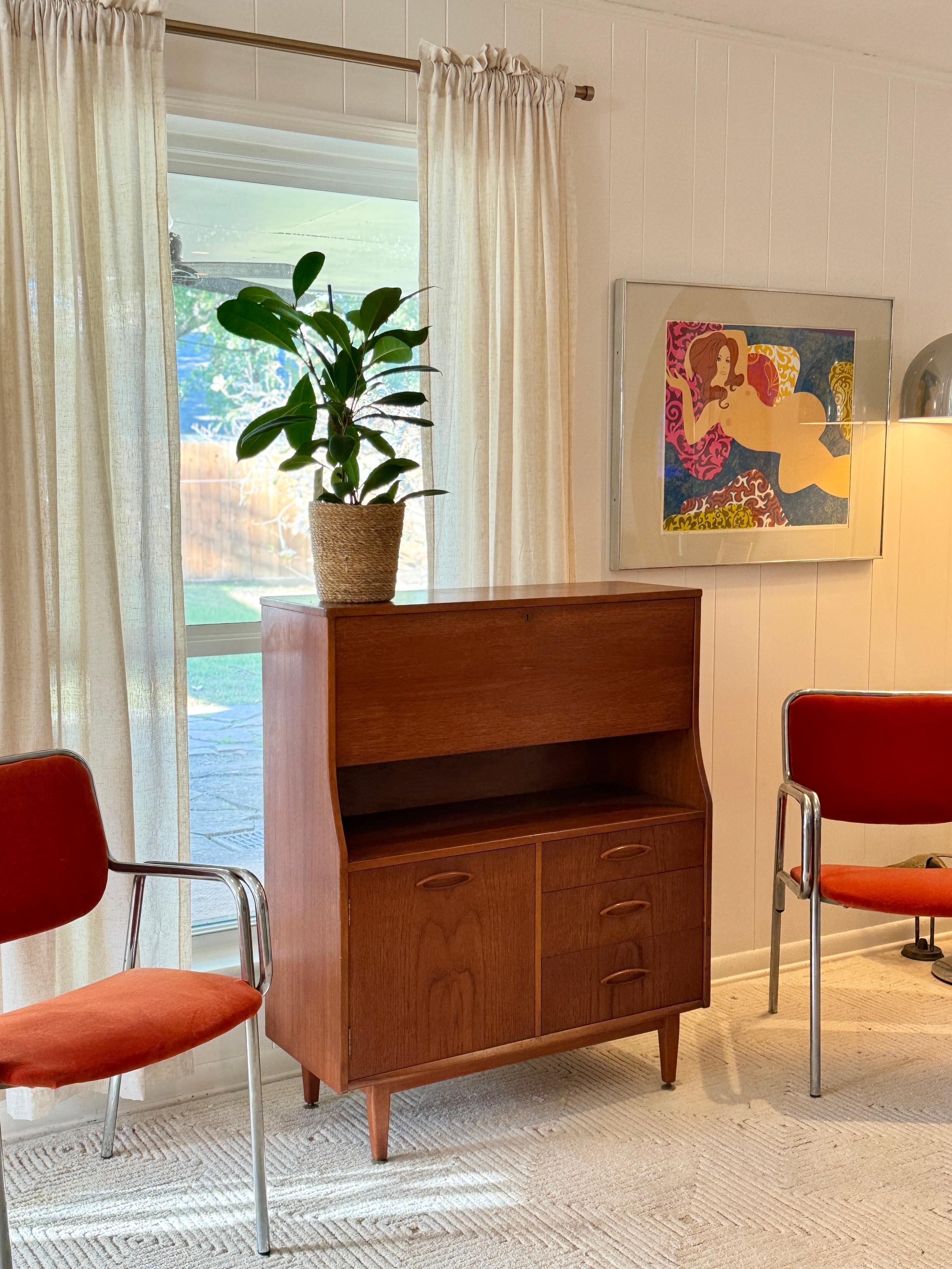 A mid century modern cabinet with a drop front desk by Jentique furniture, circa 1960s. Features a drop front writing desk, three drawers and a lower storage compartment with one shelf.  The interior of the desk has shelving and two petite drawers.