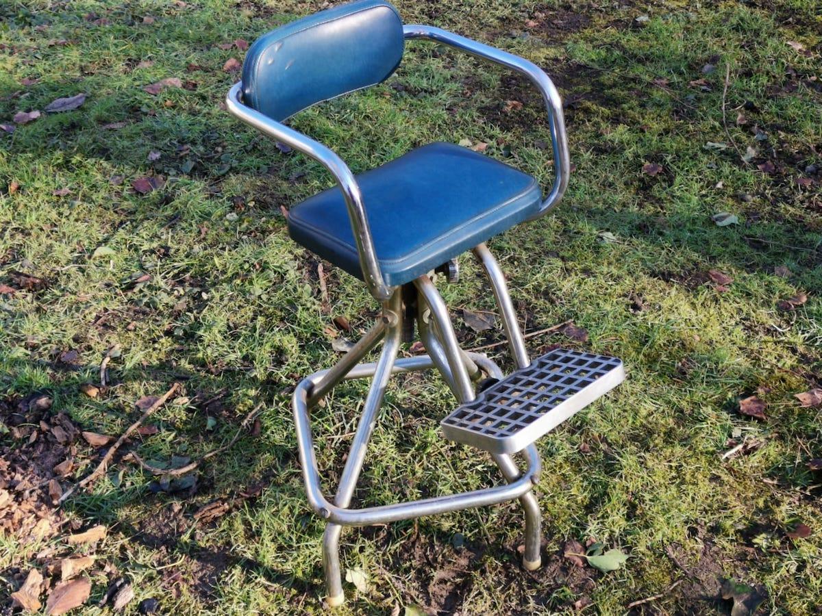 An unusual French Mid-Century Modern chrome adjustable and rotating, child's hairdressing barbers armchair with brushed aluminum footrest and the original blue vinyl upholstery. It would make a very cool desk or work table armchair or even a high