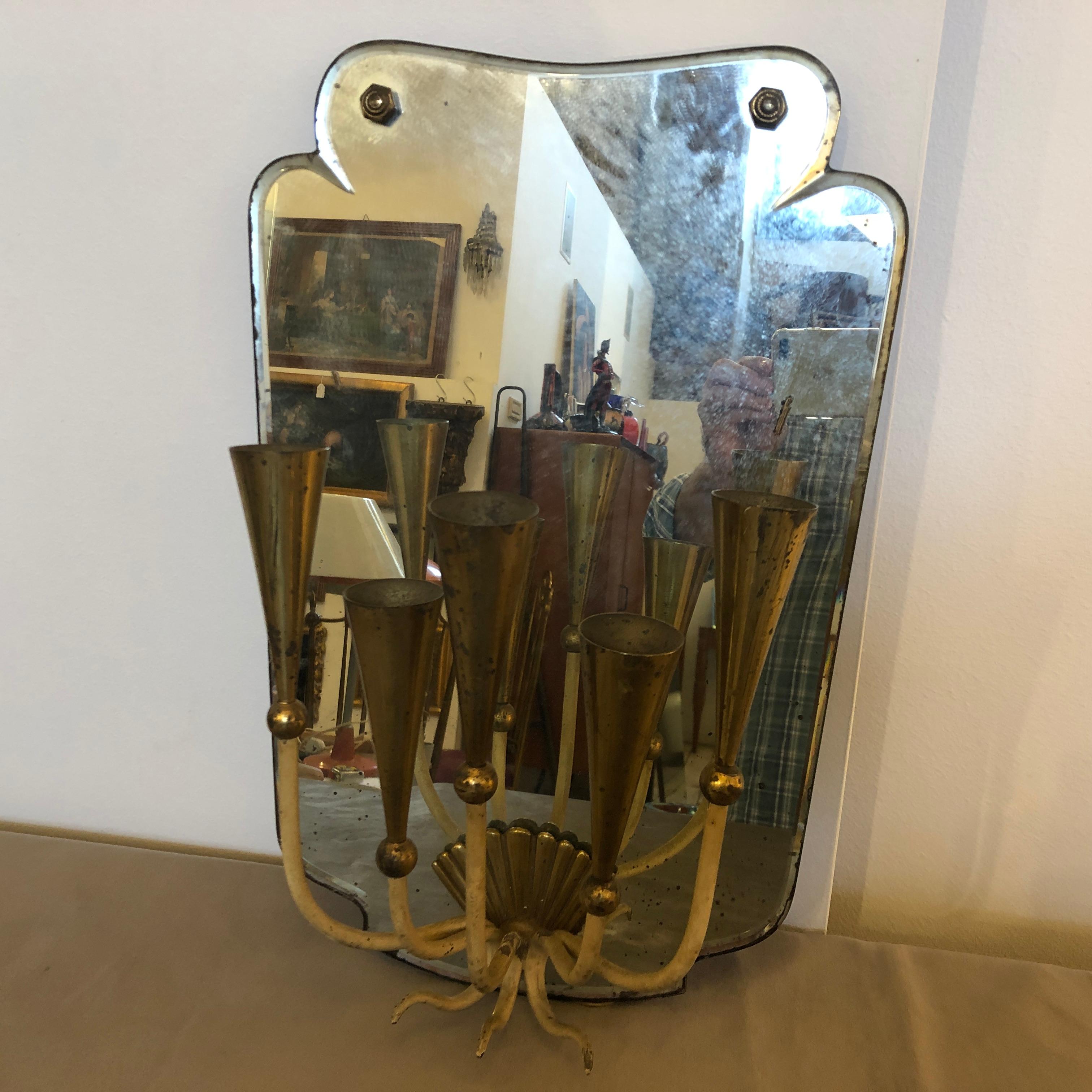 A single brass and mirror wall sconce in the style of Pietro Chiesa. Made in the Fifties, the brass is in original patina, it works 110-240 volts and need regular e14 bulbs.