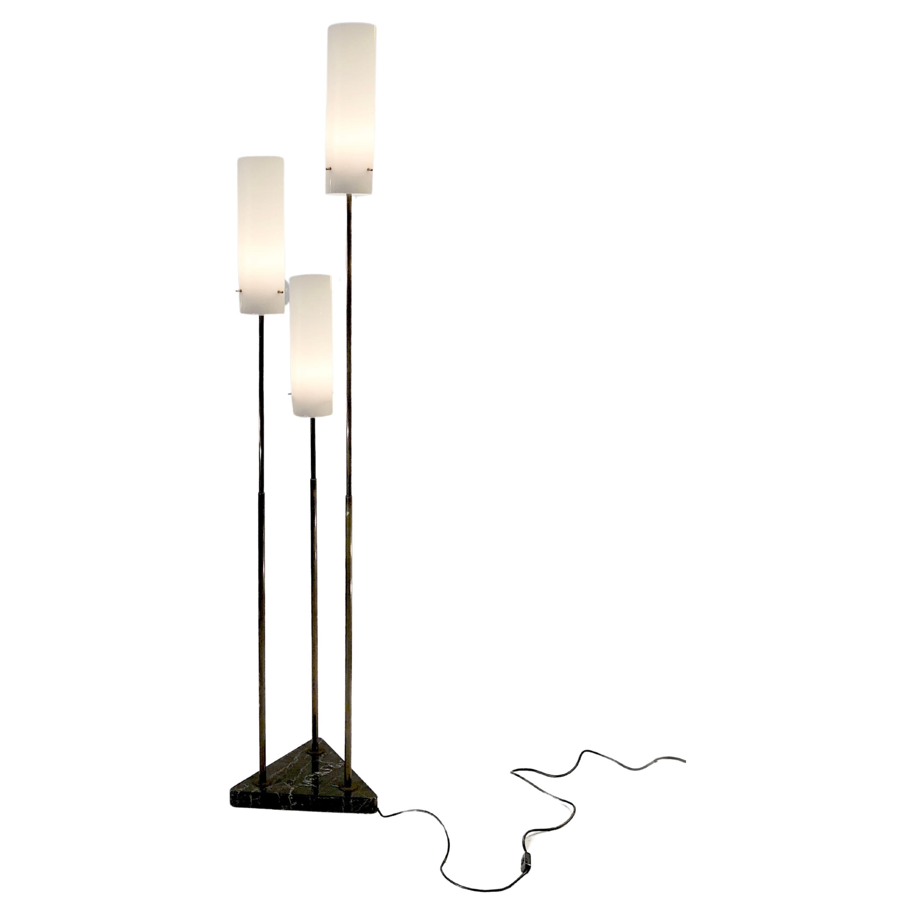 Lampadaire triple, minimal mais luxueux, Mid-Century-Modern,  dans l'esprit de Tito Agnoli pour O-Luce, Italie 1950. Un épais socle triangulaire en marbre noir pèse sur l'ensemble de la lampe. 3 fines baguettes verticales en bronze, qui semblent