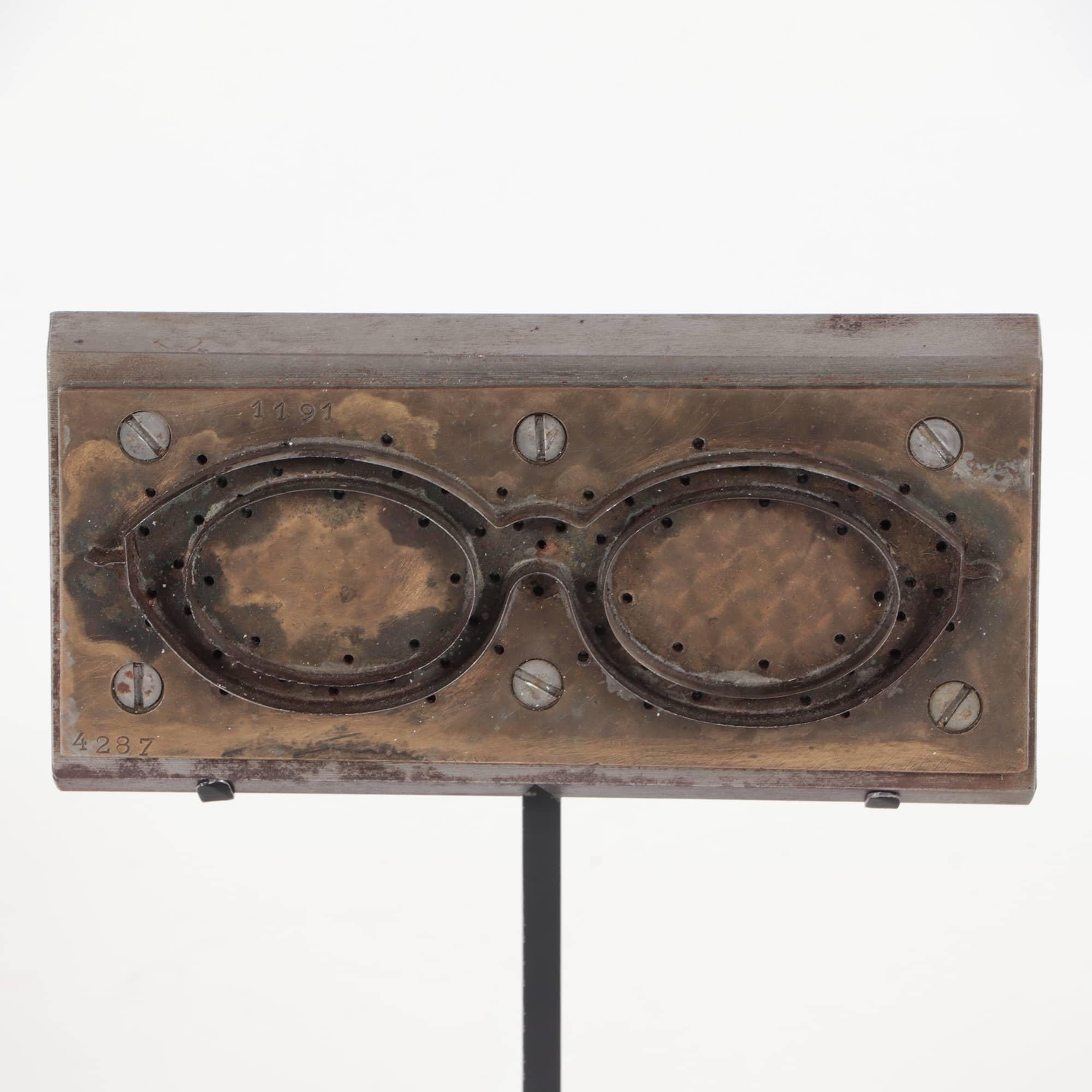 A Mid-Century Modern French steel and brass eyeglasses mold on a custom iron base, circa 1950.