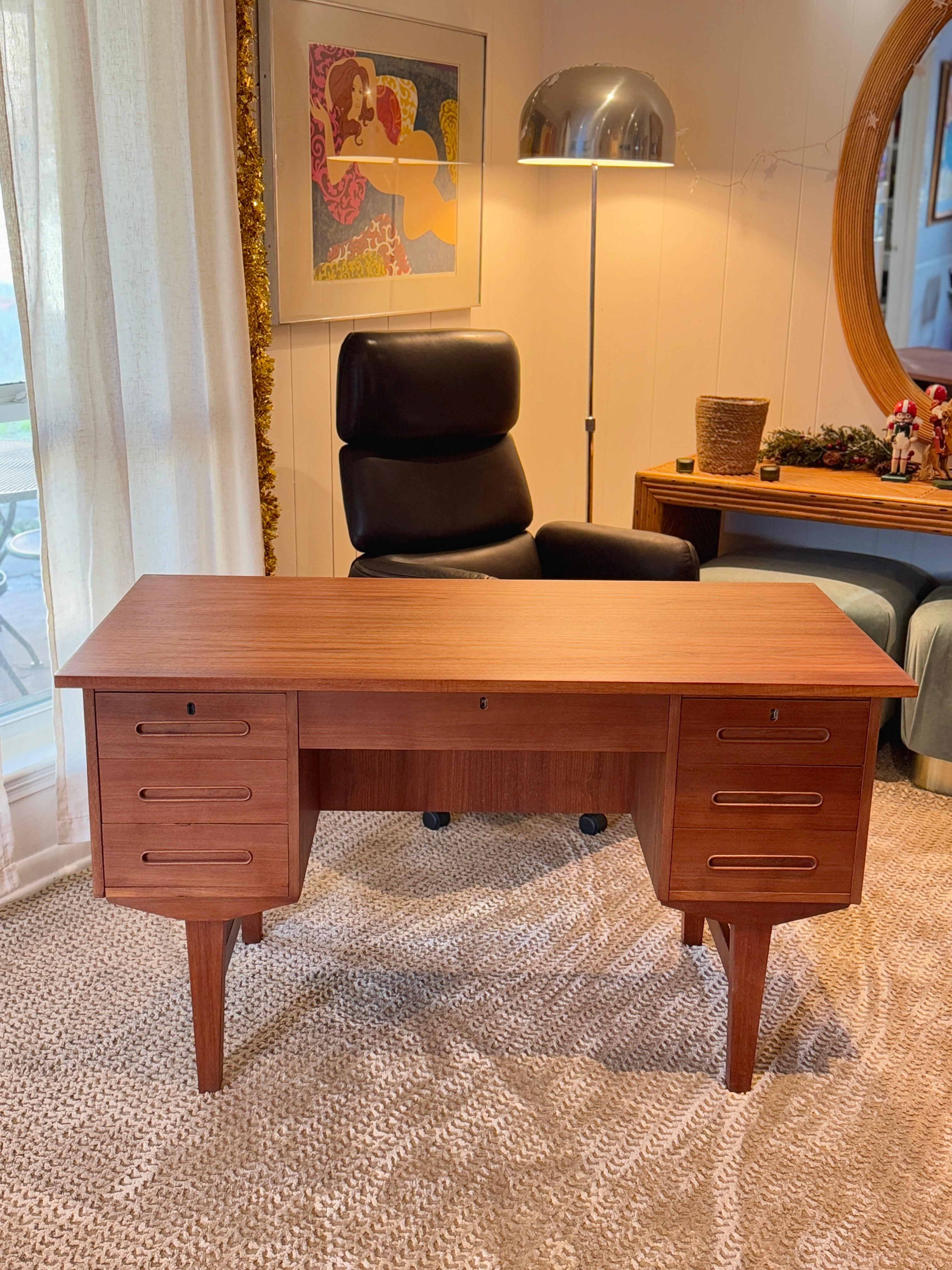 Una scrivania frontale moderna di metà secolo, realizzata in Danimarca, intorno agli anni Sessanta. Questa scrivania incarna l'eleganza e la funzionalità senza tempo del design scandinavo. Realizzata in teak dalle tonalità intense, vanta linee