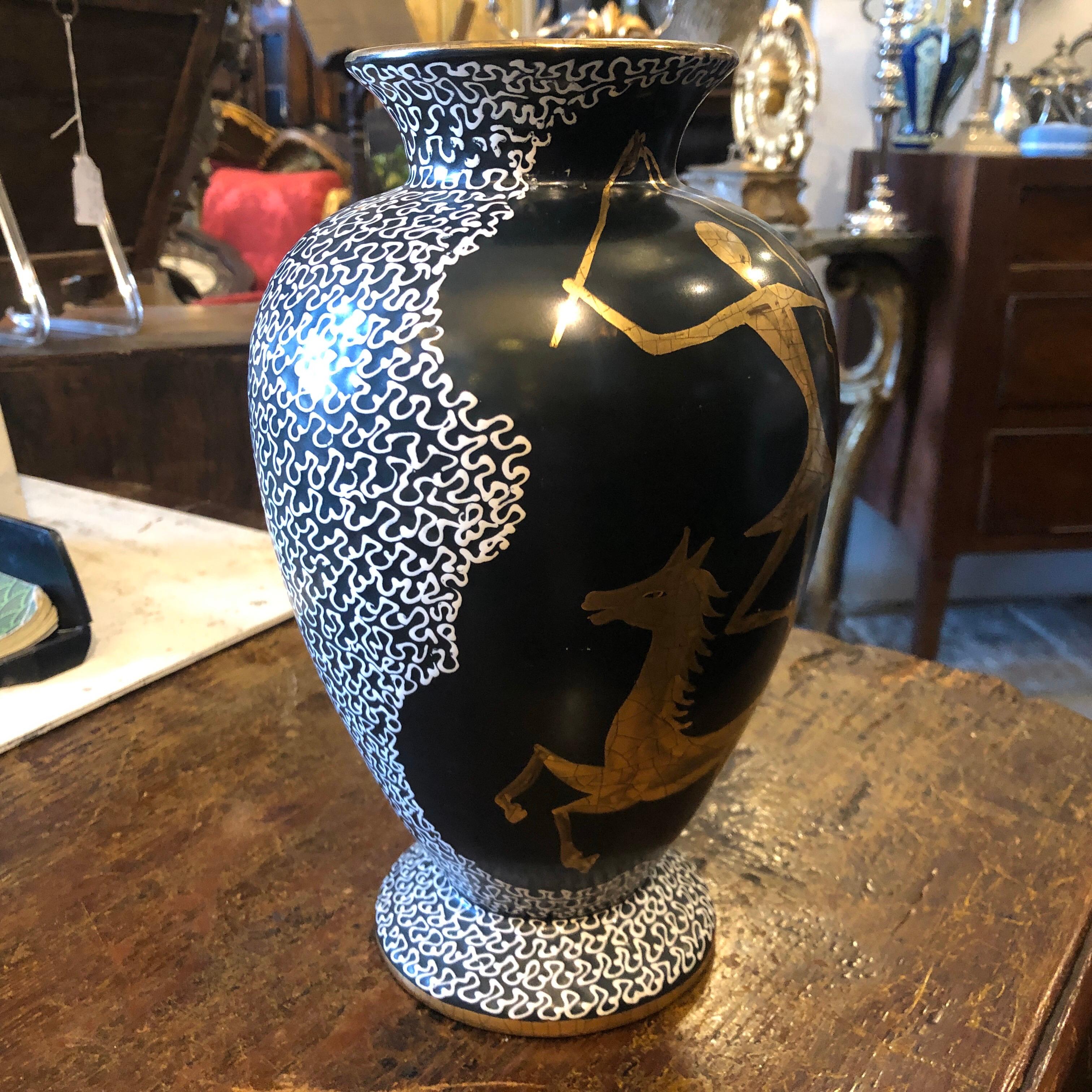 A stylish handcrafted ceramic vase made in Italy in the 1960s, hand painted gold figures. It's signed on the bottom with the name of the shop in Syracuse in Sicily and a number.