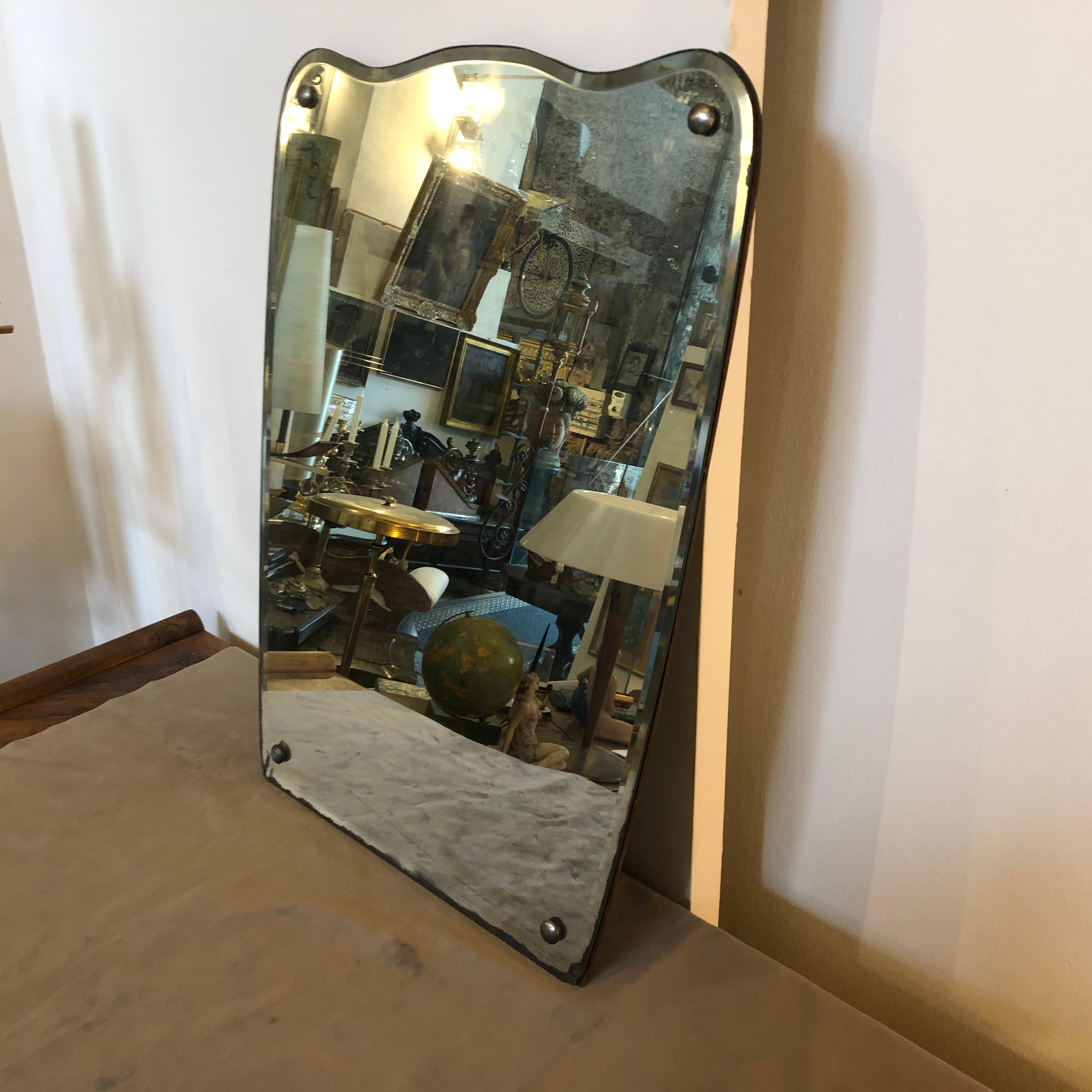 Stylish Mid-Century Modern wall mirror, good conditions overall, it has real signs of the age on the mirrored glass. It's labeled Lugi Fortuna on the backside. The first photo is retouched by 1stdibs, please look all others photos where you can see