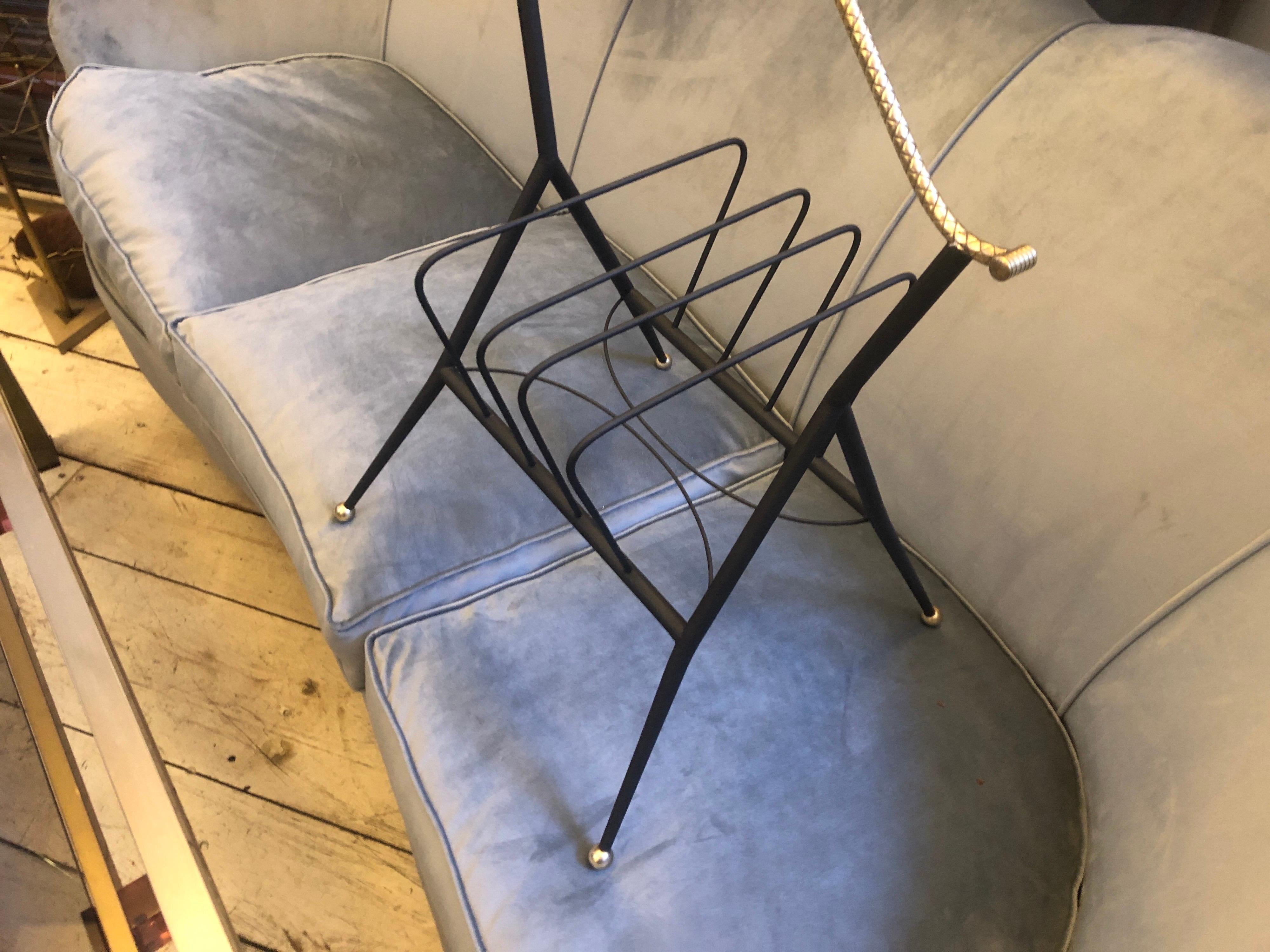 An elegant brass and black metal magazine rack made in Italy in the 1950s, item has been cleaned and restored in original colors, now it's in lovely conditions. This Italian magazine rack embodies the distinctive design elements characteristic of