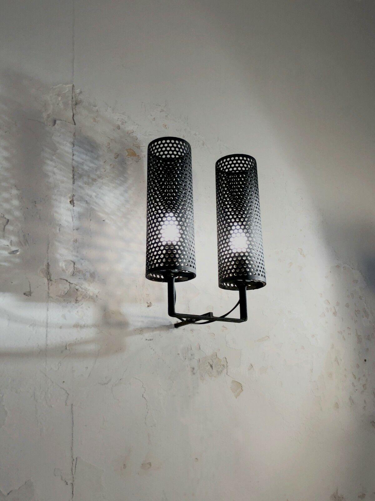 A wall lamp with 2 arms of light, Modernist, Bauhaus, Constructivist, Free Form, in thick black and perforated ironwork, in the style of Mathieu Matégot, to be attributed, France 1950.
Exceptional manufacturing quality.
The wall light can literally