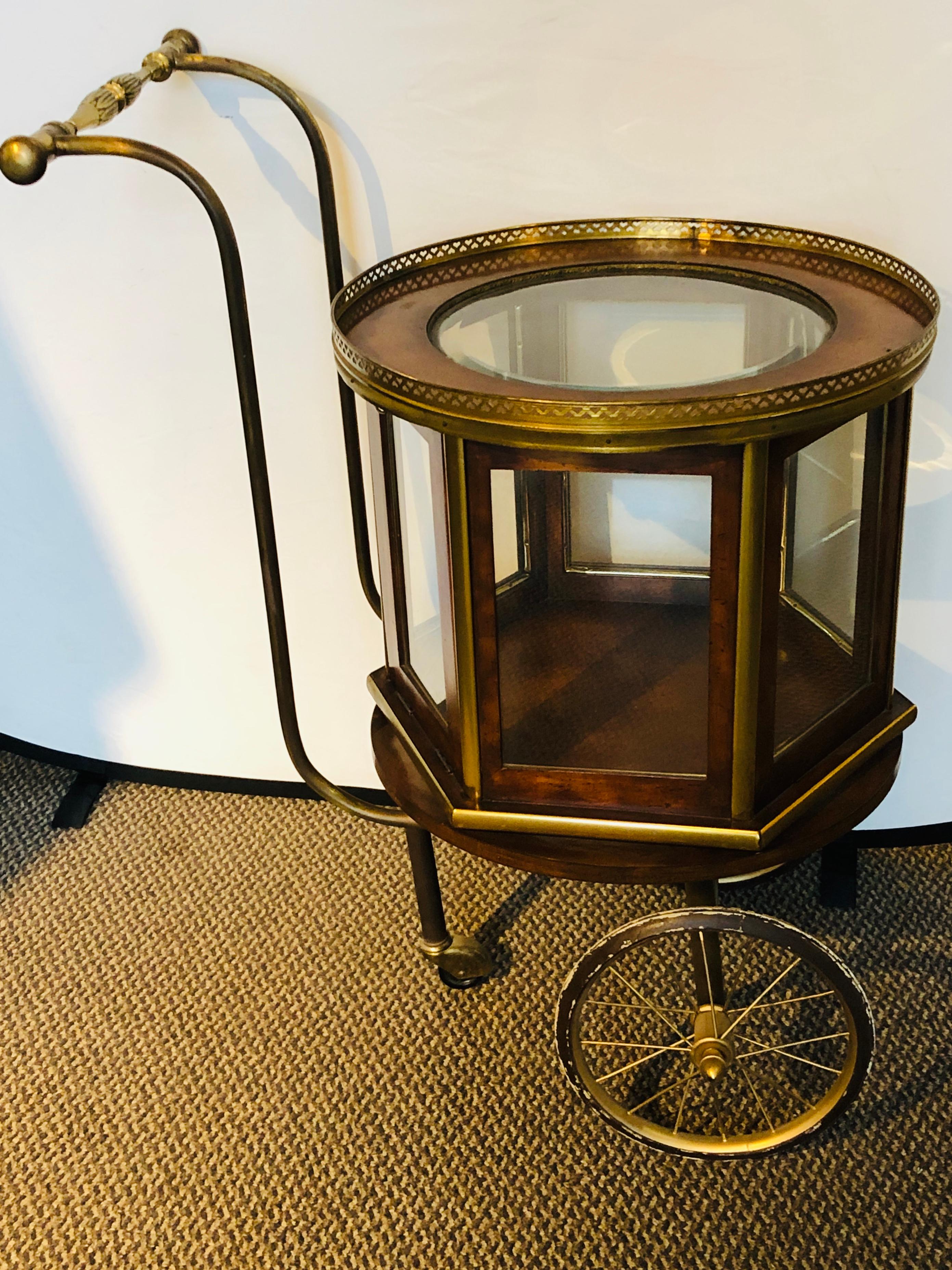 A Mid-Century Modern revolving serving cart or bar cart having beveled glass with fine bronze mounts. This stunning Mid-Century Modern bar cart is a must have for any serving occasion. The fully revolving top has two opening doors with a showcase