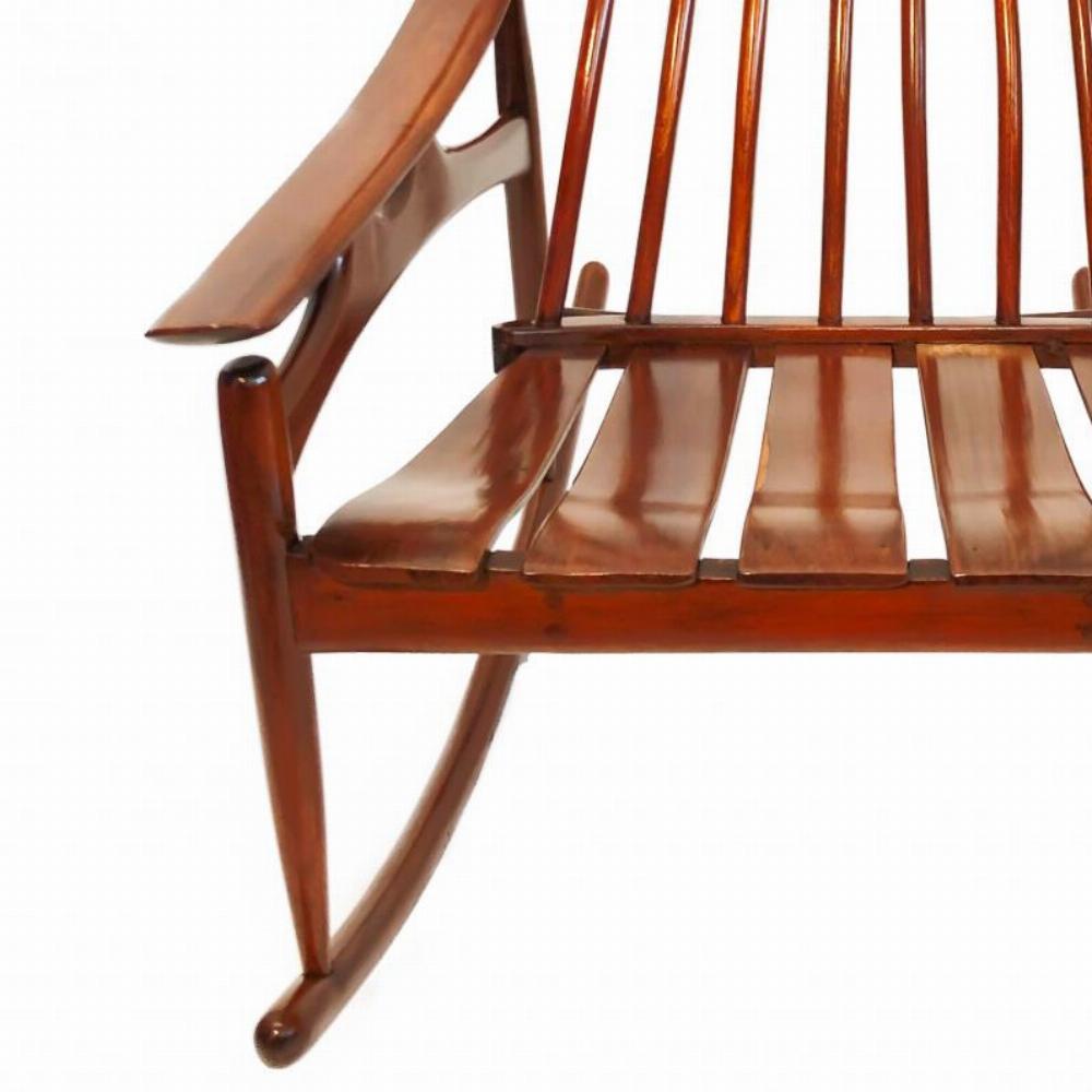 Una sedia a dondolo del Mid-Century Modern finemente lavorata, caratterizzata da linee eleganti e scultoree e da un armonioso equilibrio tra forma e funzione. La sedia mostra l'uso caratteristico dell'epoca di materiali naturali, con una cresta