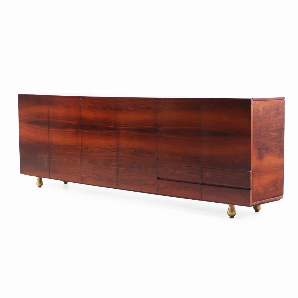 Un atractivo y sustancial aparador de seis puertas fabricado en palisandro ricamente labrado. El frente muestra impresionantes chapados a juego en 6 puertas y 2 cajones cortos, que resaltan la belleza natural y la simetría de las vetas de la madera.