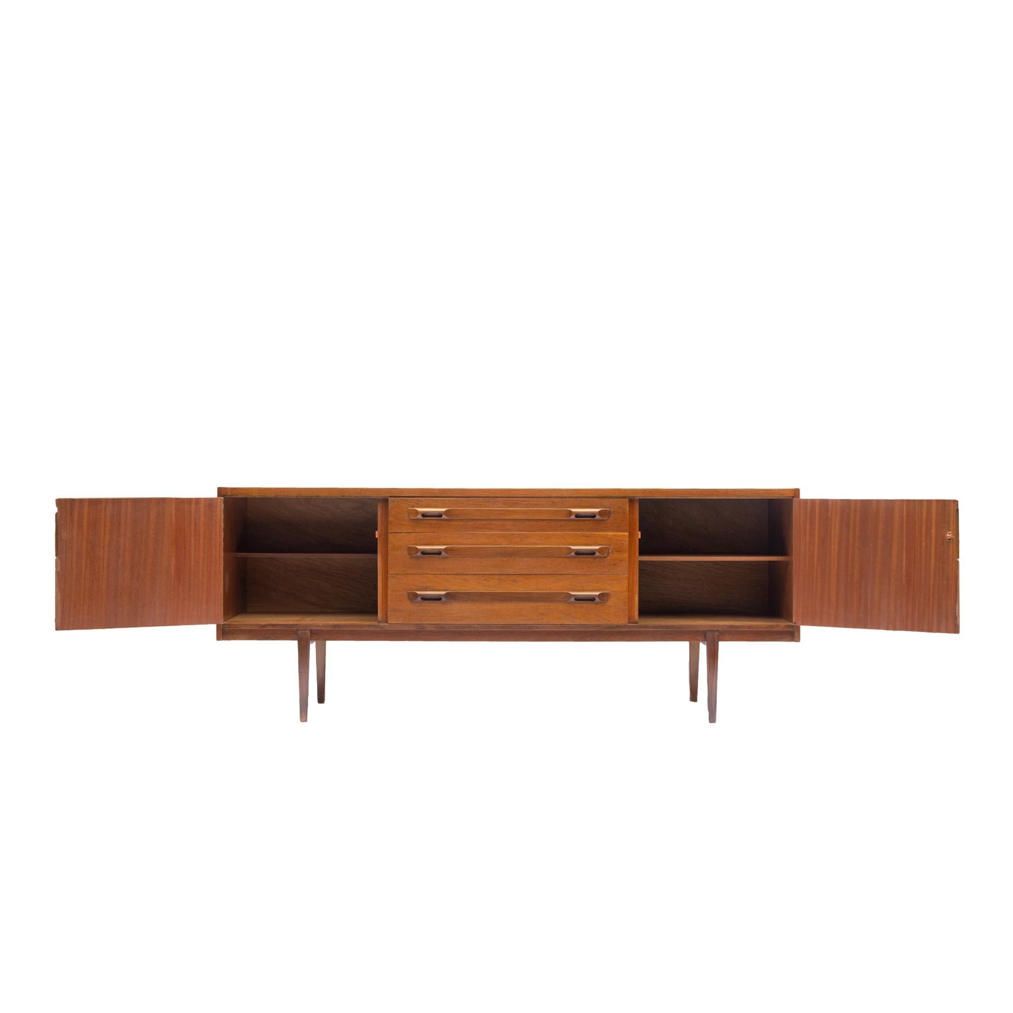 A Mid-Century Modern Teak and Afromosia Sideboard by Wrighton of Danish Modern form, the center section with three drawers, the top one fitted for cutlery, each with sculpted organic pulls, with cabinet doors to either side, English, circa 1960.