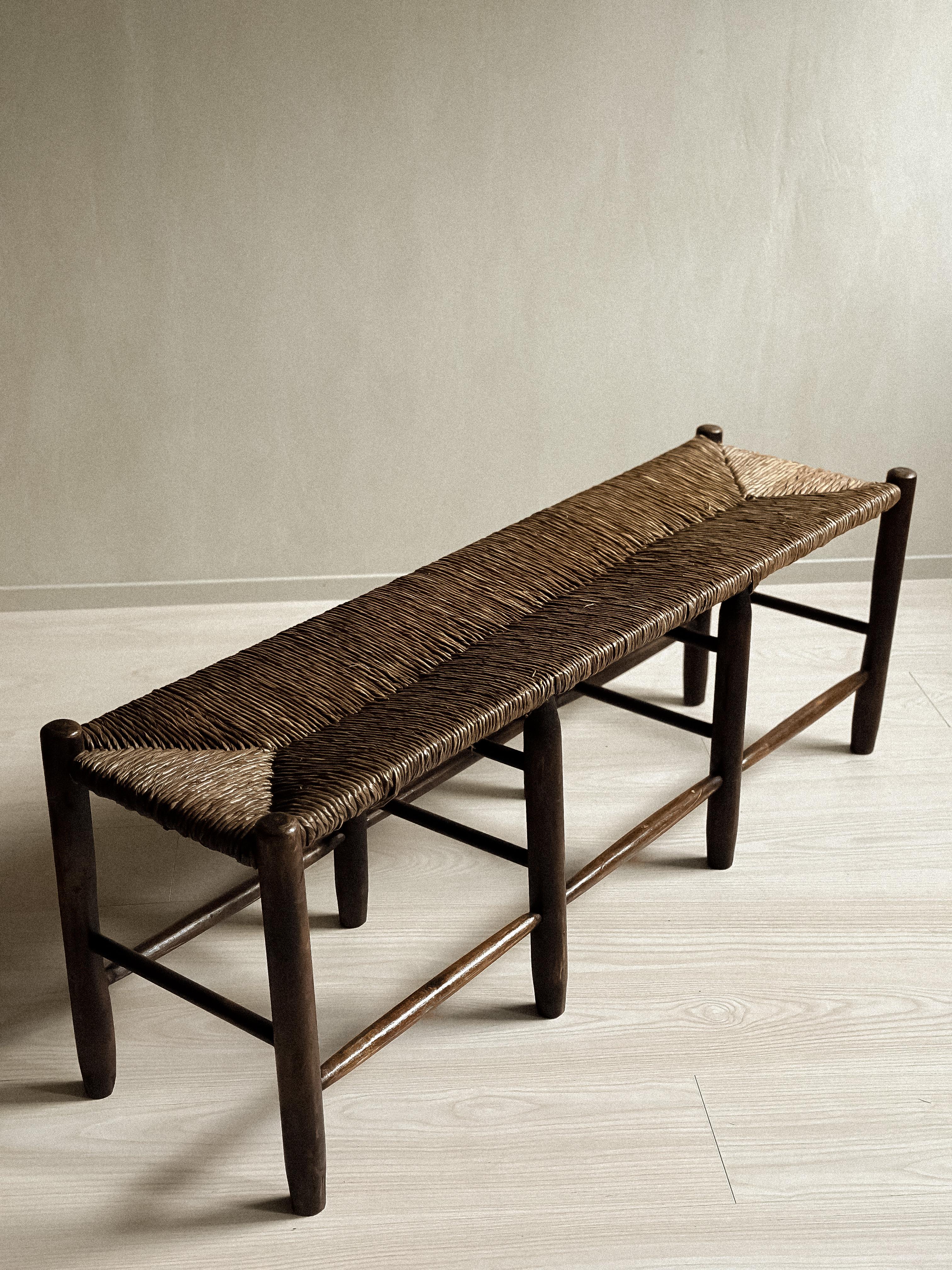 A beautiful Mid-Century Rush bench in dark stained Oak in the manner of Charlotte Perriand. Designed by French anonomus designer, c. 1950s. In good vintage condition. Wear consitent with age and use. 