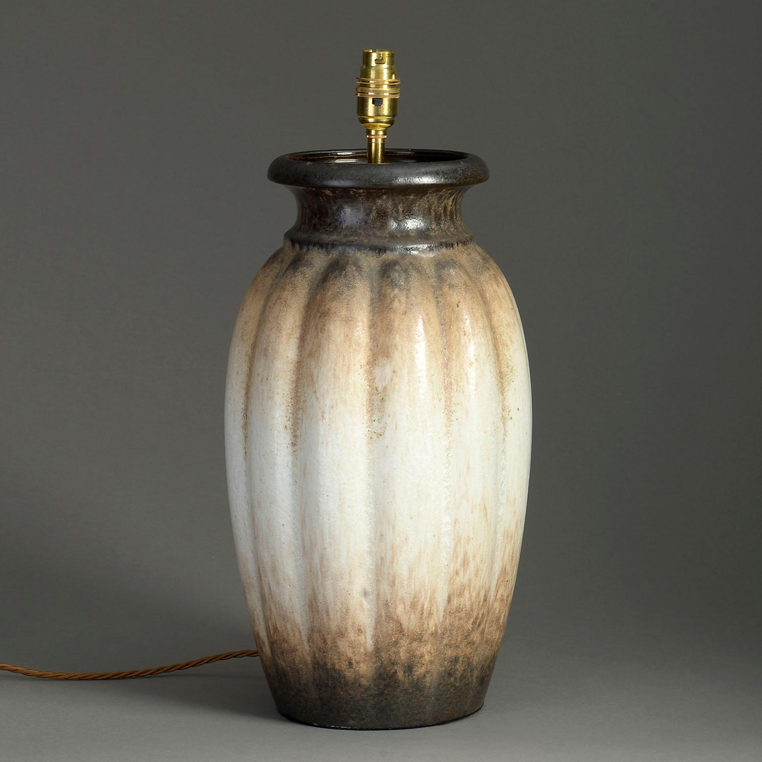 Un grand vase d'art en poterie, le corps de forme généreusement nervurée, avec une glaçure cappuccino tachetée sur toute la surface.

Maintenant monté comme une lampe

Les dimensions se réfèrent au vase.

L'abat-jour n'est pas inclus.