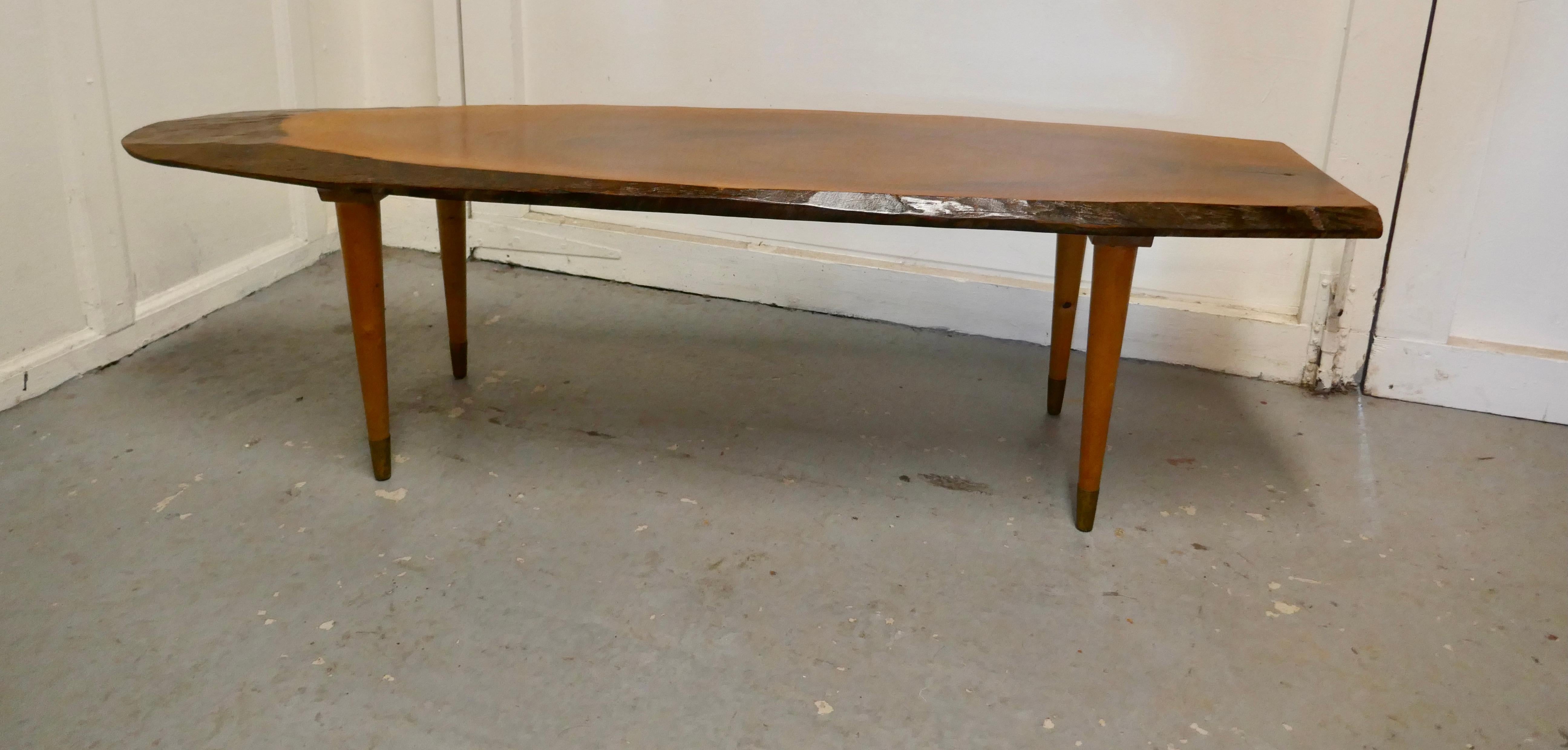 A mid century slice of fruitwood coffee table

This is a magnificent piece, a solid slice cut from the tree with neat tapered beech legs
The table has a rustic designer look and is smooth with a superb patina, even the outer edges are smooth to