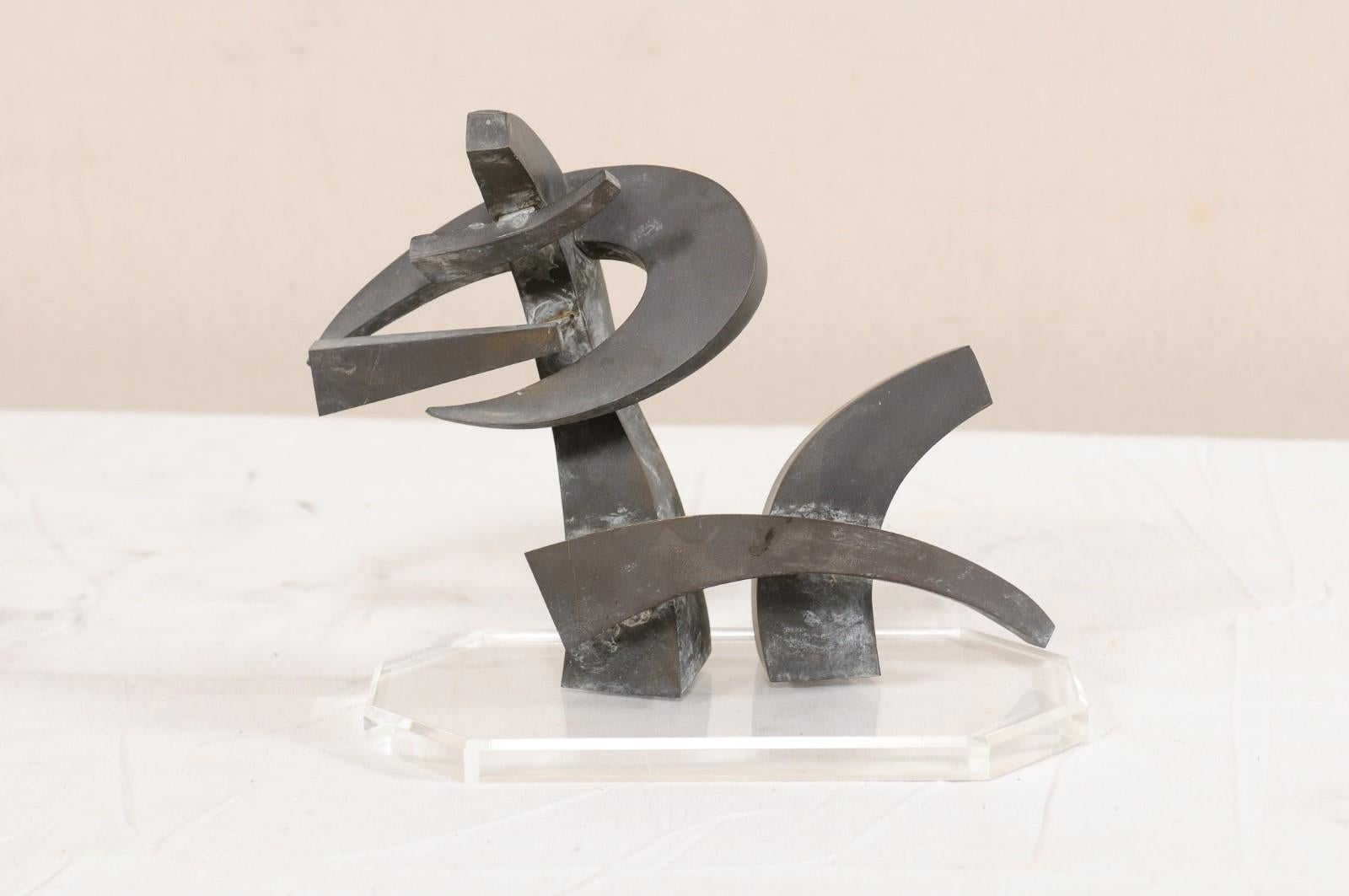 A European small-sized abstract sculpture from the mid-20th century. This vintage European abstract art piece has been created in bronze, and has a wonderful dark patina. It has been custom mounted on a clear, Lucite base. This midcentury art
