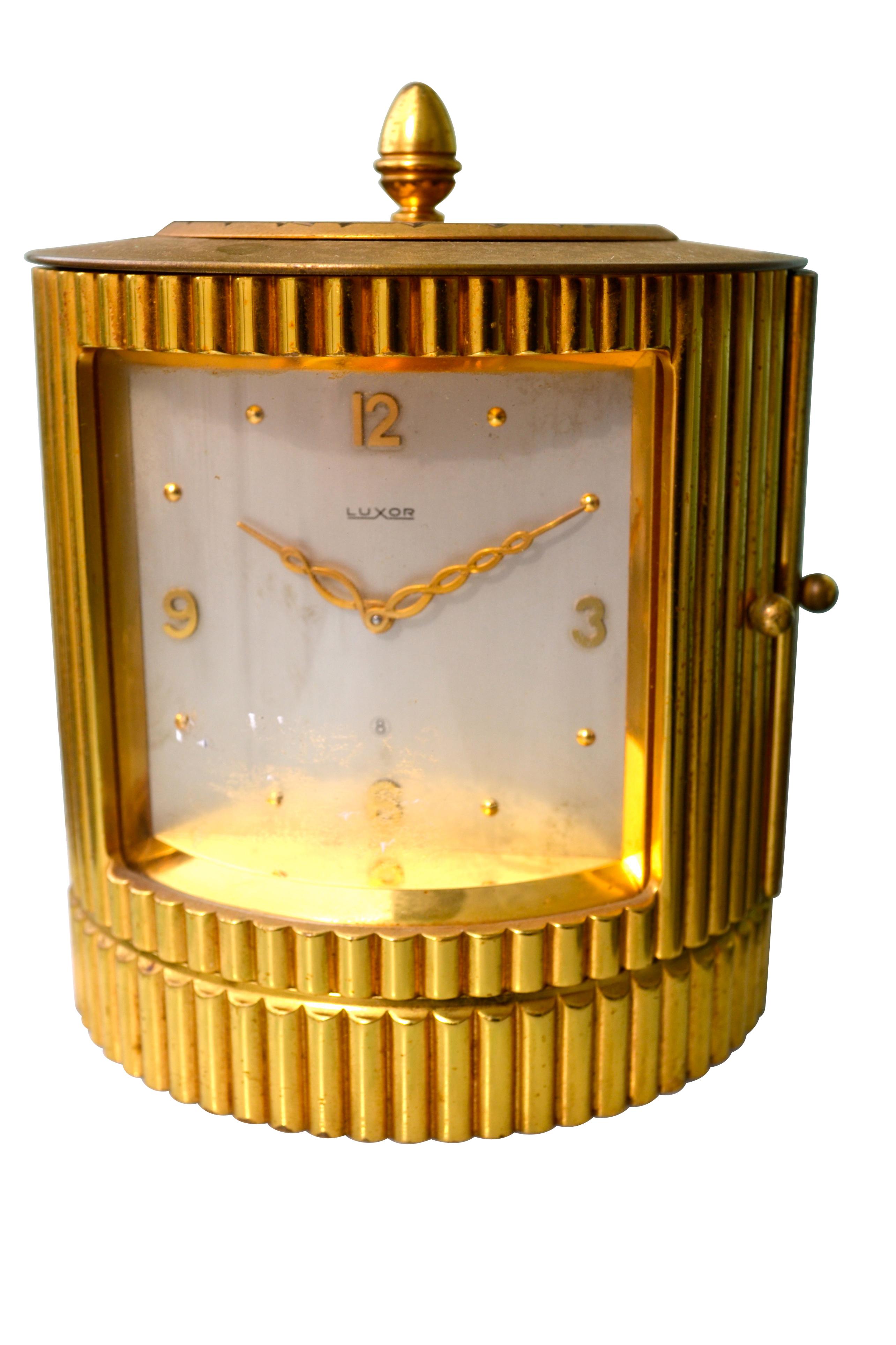 An unusual combination table clock and cigarette holder from the early 1950s made by a Swiss Company called Luxor that no longer is in business. The base also has a compartment originally for holding cigarettes or it could be used as a holder for
