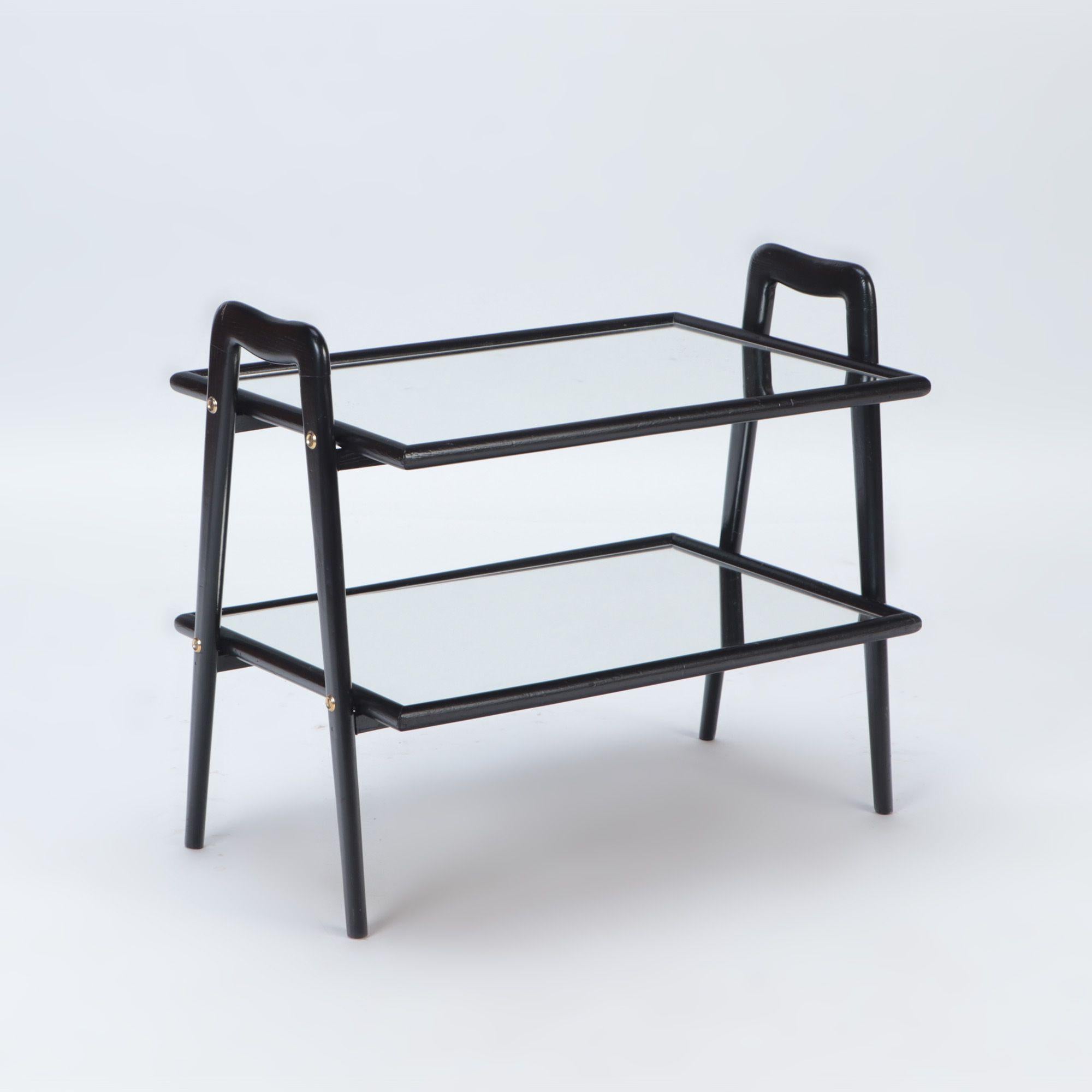 A Mid Century two tier ebonized and glass tray table, circa 1950.