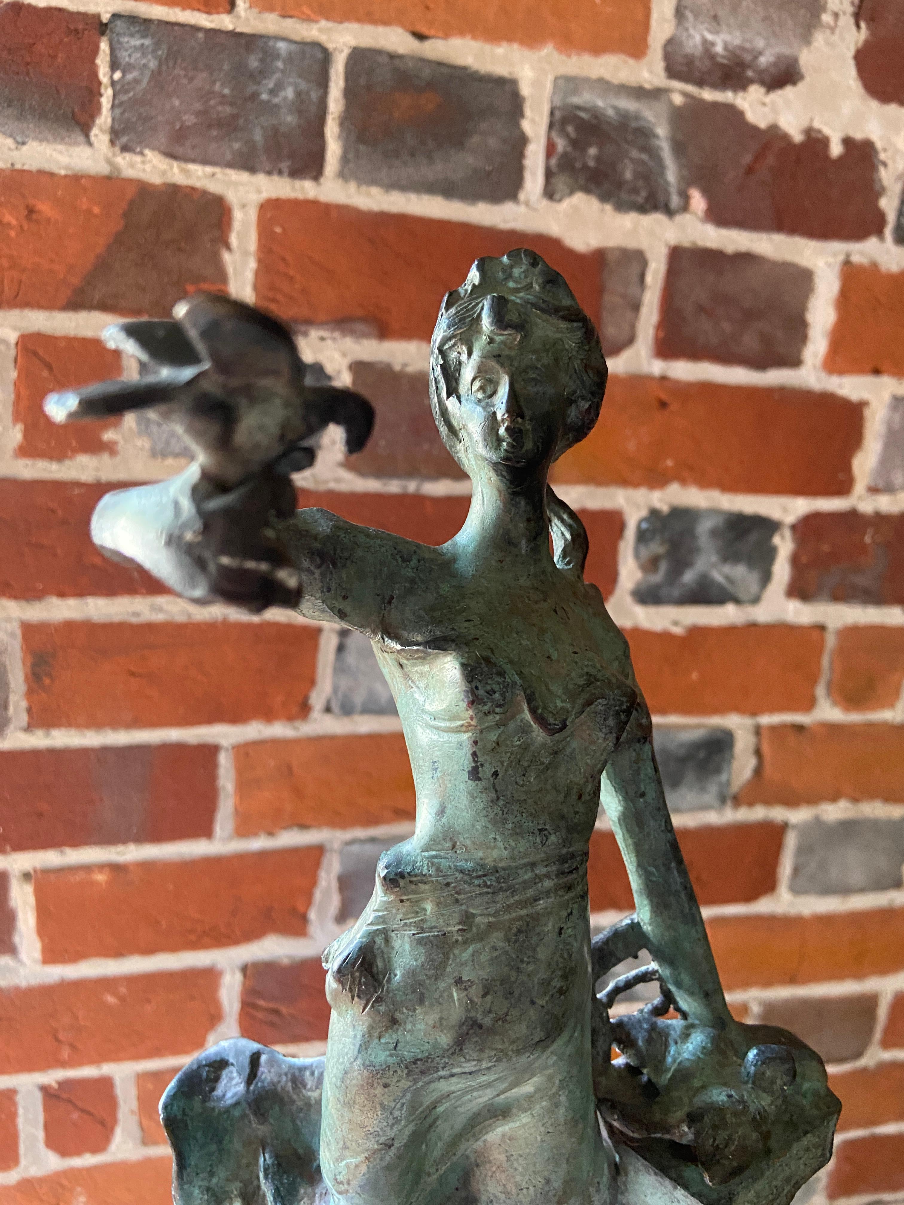 Cast Mid-Century verdigris bronze figure of a girl releasing doves For Sale