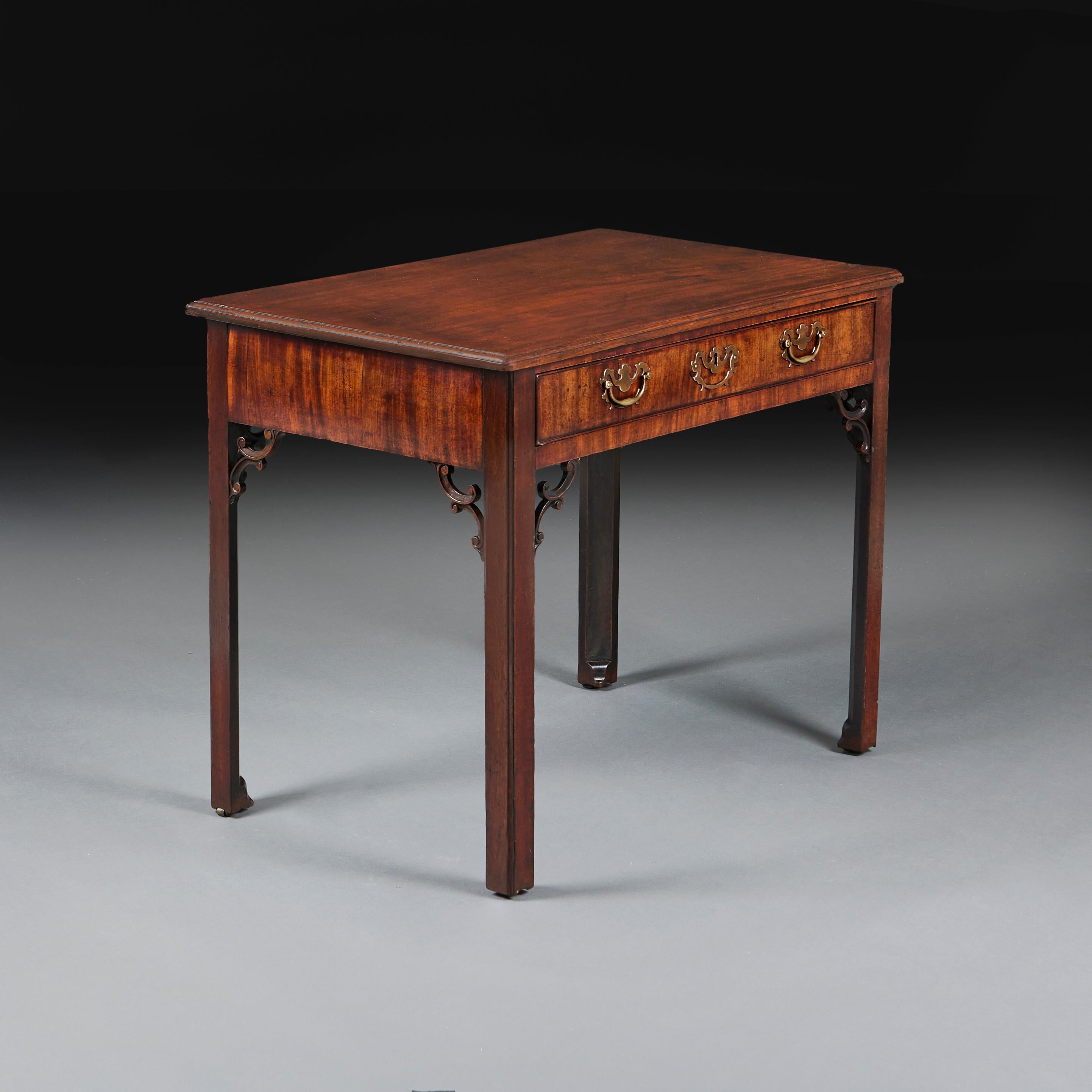 Table d'appoint en acajou du milieu du XVIIIe siècle, avec plateau mouluré, un tiroir sur la frise avec des poignées et des écussons en laiton, avec des consoles d'angle rococo percées, le tout reposant sur quatre pieds cannelés.