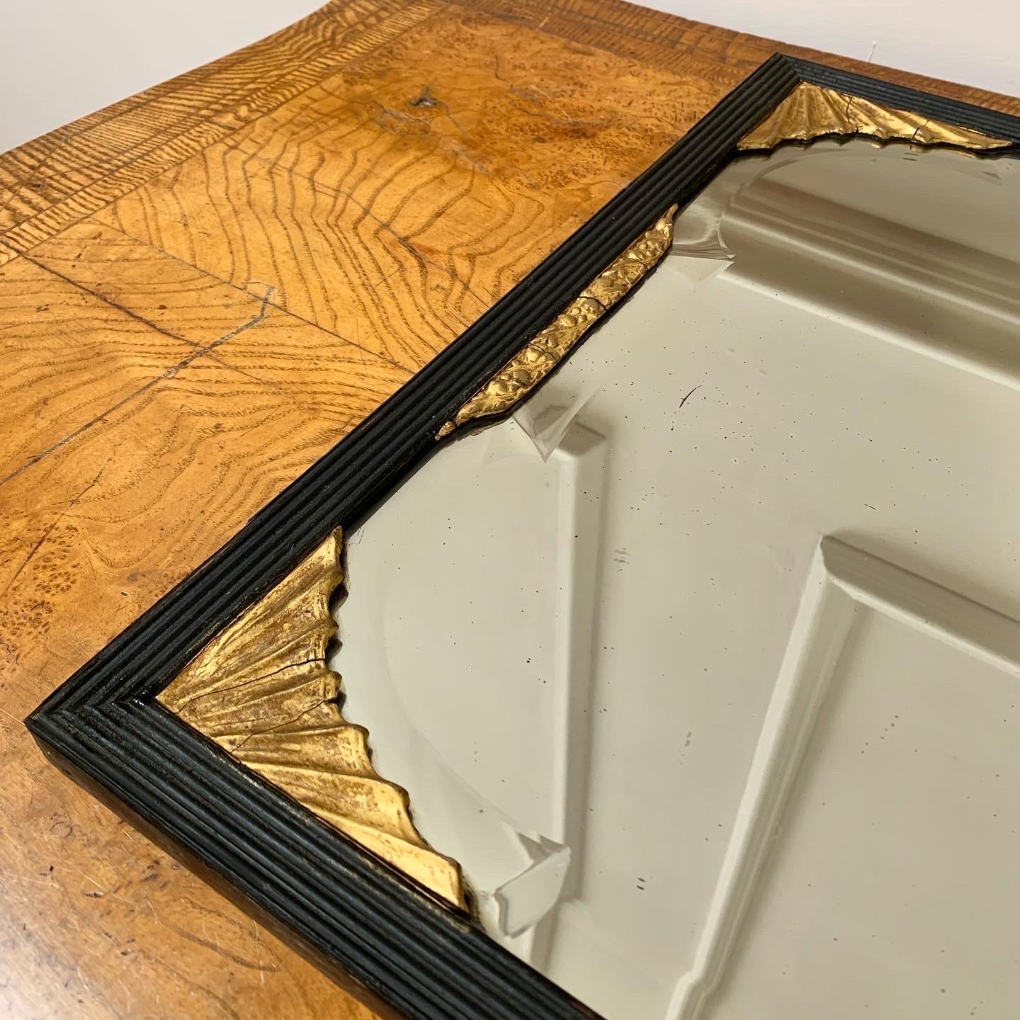 Specchio di Vauxhall della metà del XVIII secolo dalle proporzioni eleganti, il piatto è di forma rettangolare con parte superiore a doppio arco e bordo smussato, in una cornice ebanizzata e ribattuta di epoca più tarda con applicazioni dorate agli
