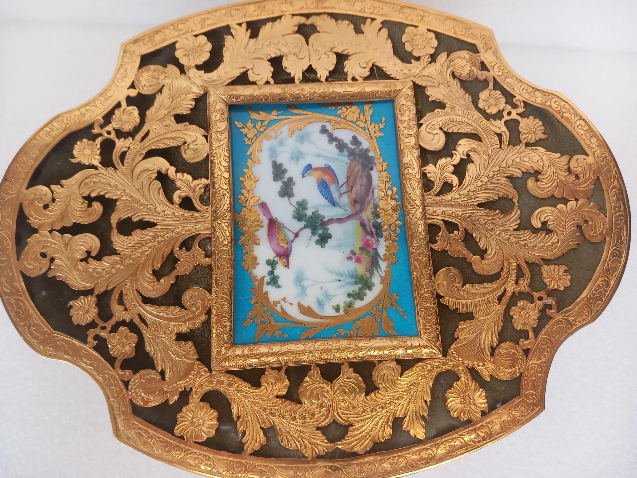 A  mid nineteenth century French ormolu casket with a central Sèvres porcelain cartouche painted in the eighteenth century style. 
The gilded ormolu is elaborately carved with feathered leaves and flowers. 
Quatrefoil in shape , this very elegant