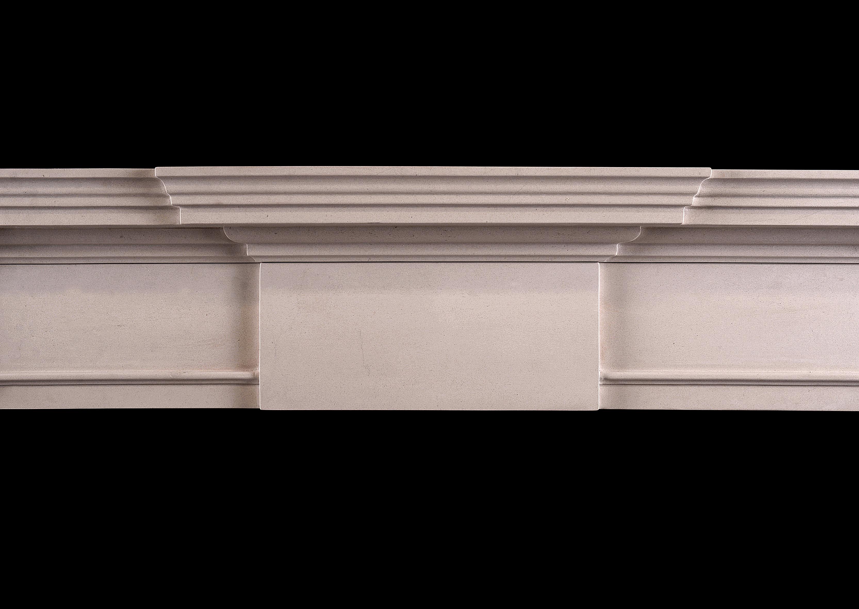 A mid-sized English Georgian style limestone fireplace. The plain jambs surmounted by scotia moulding and plain end blocks. The frieze with plain centre panel with moulded shelf above. An attractively simple model in the classical style. Modern.
