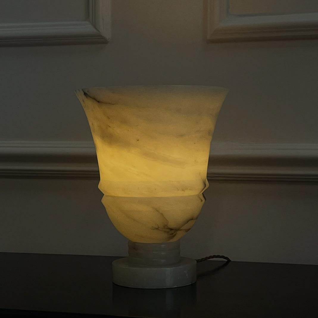 Aplique de mediados de siglo, de inspiración Decó, de forma acampanada en alabastro blanco con vetas grises sobre columna estriada y base circular.

Francés, mediados del siglo XX

Alto 31 x Ancho 25 cm
