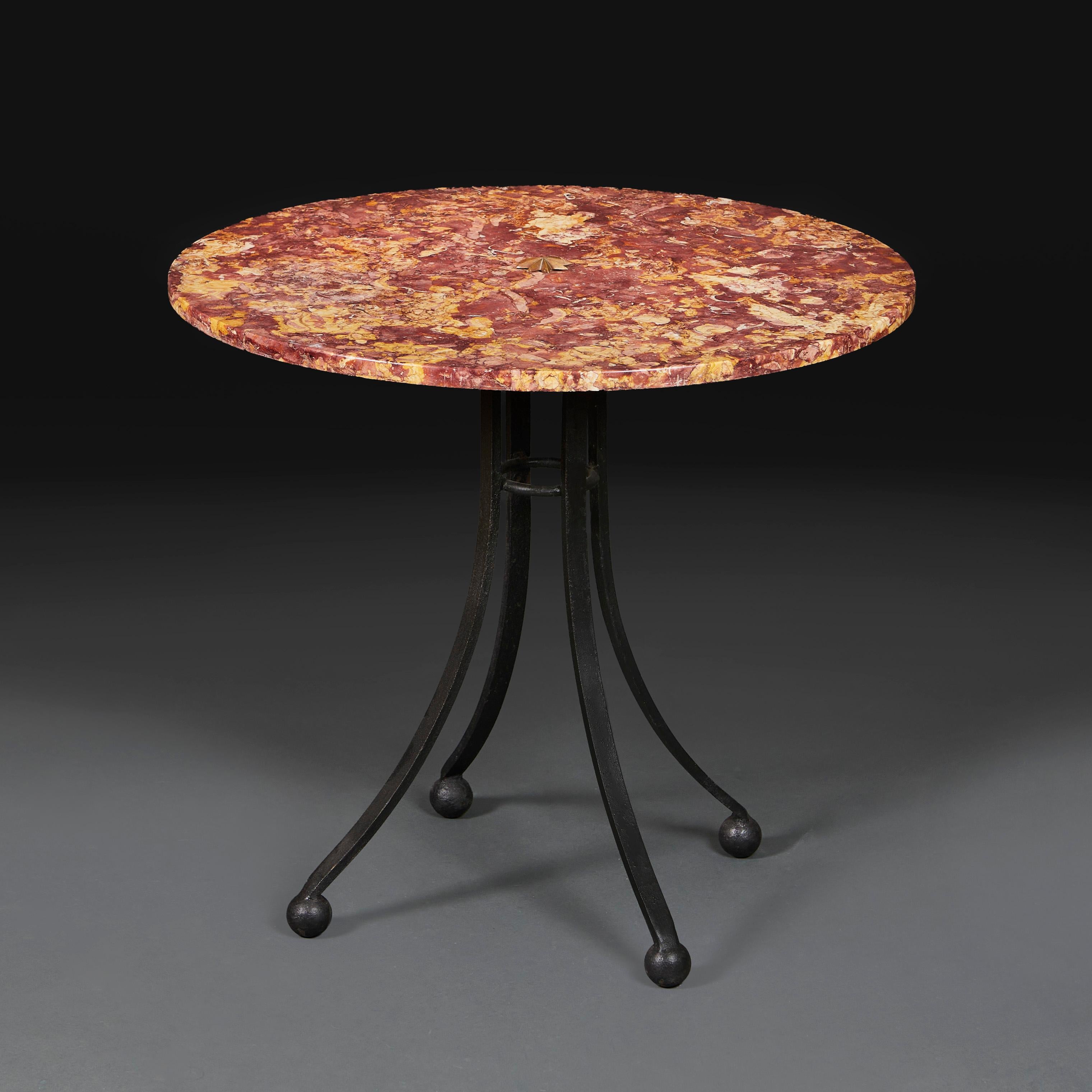 France, circa 1950.

An unusual mid twentieth century French marble gueridon, the spectacular circular red marble top supported on a wrought iron base with four splayed legs, terminating in ball feet, the top with a brass star to the centre.

Height