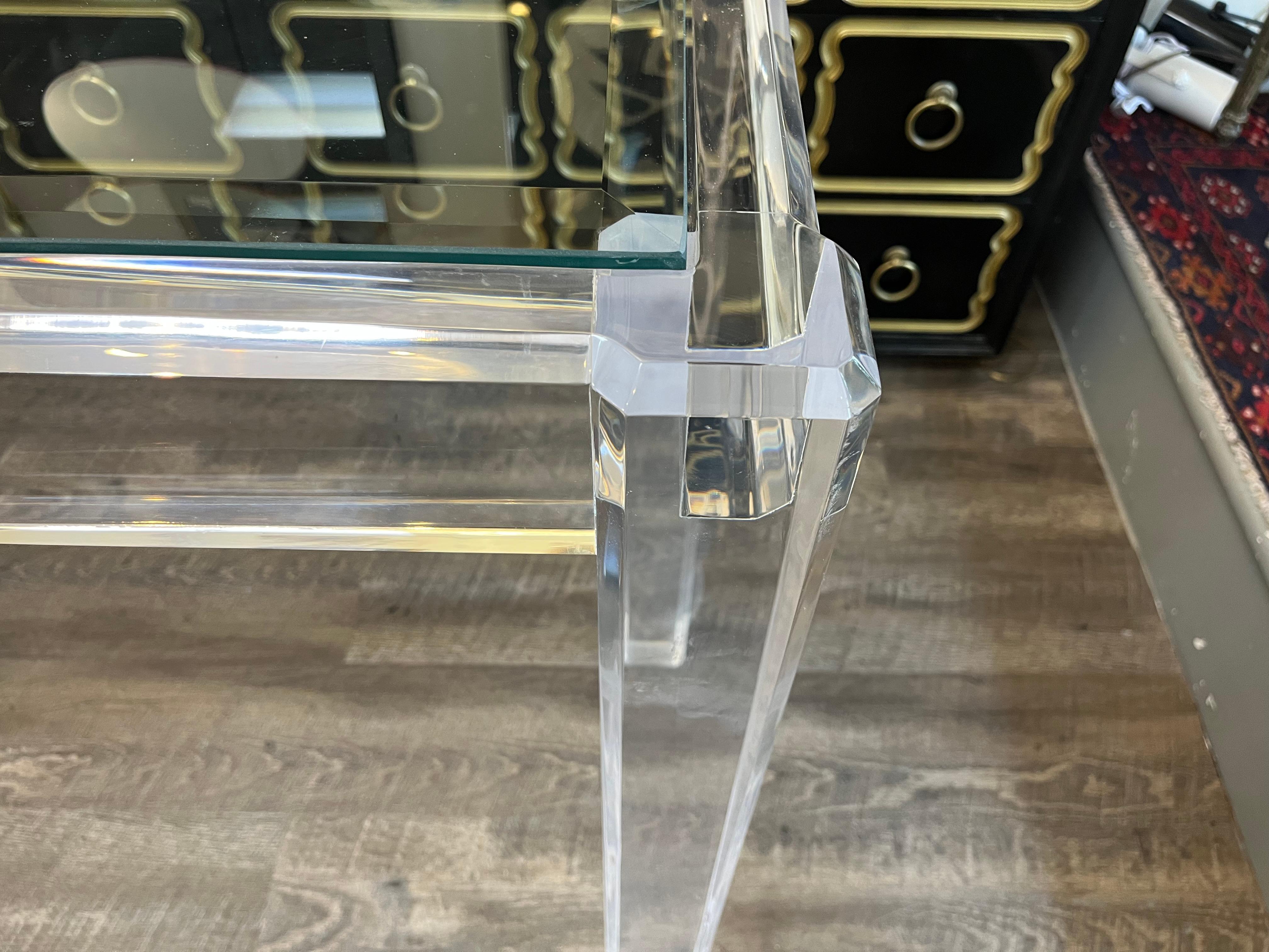 Importante consola Lucite Hollywood Regency de los años setenta, con tapa de cristal insertada sobre sólidas patas cuadradas.