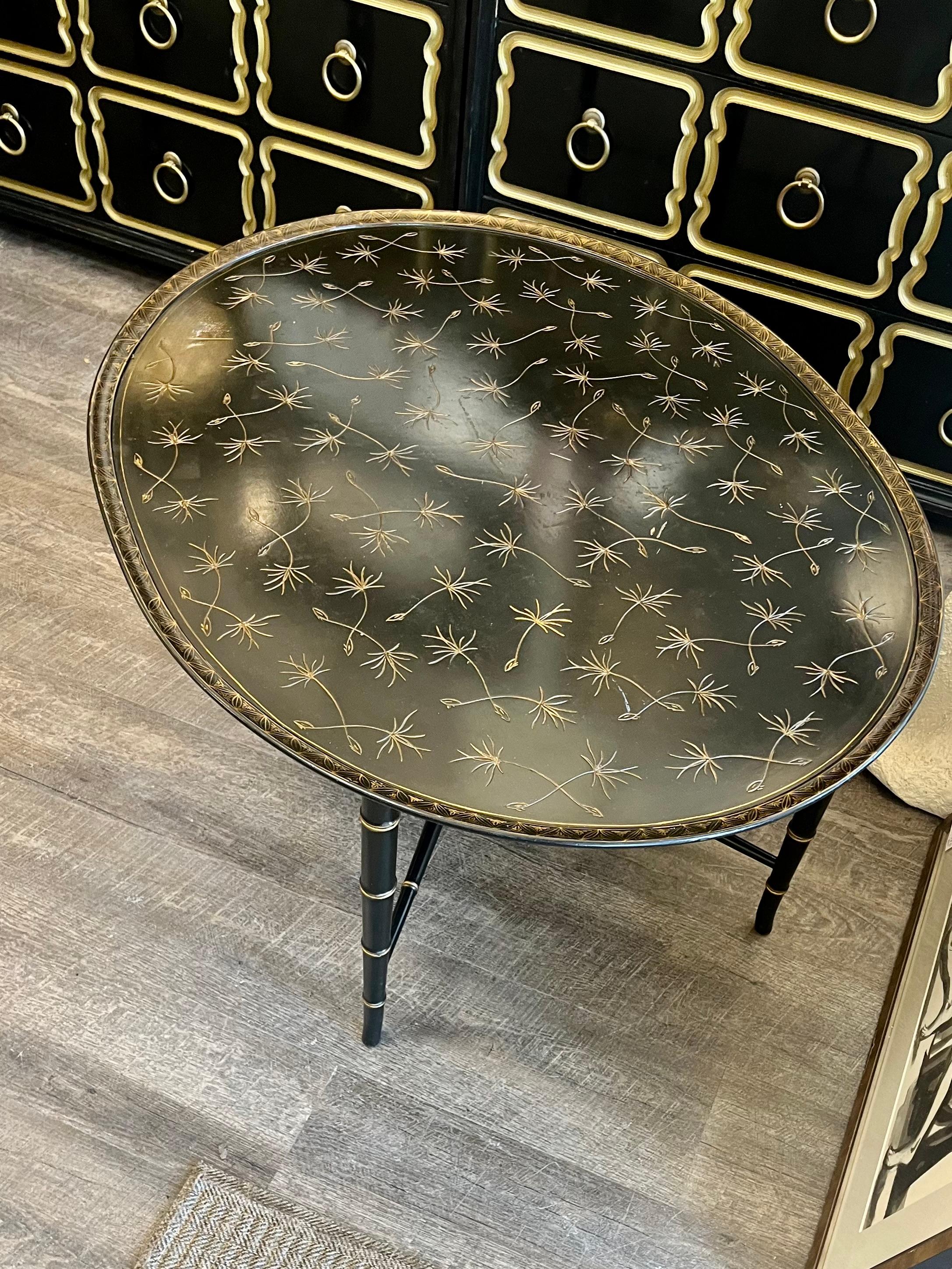 Tavolo da cocktail ovale della metà del XX secolo con gambe in finto bambù rifinite in ebano e dorate. Intricati dettagli a tratteggio incrociato sul perimetro, opera di Kittinger Furniture Company. 