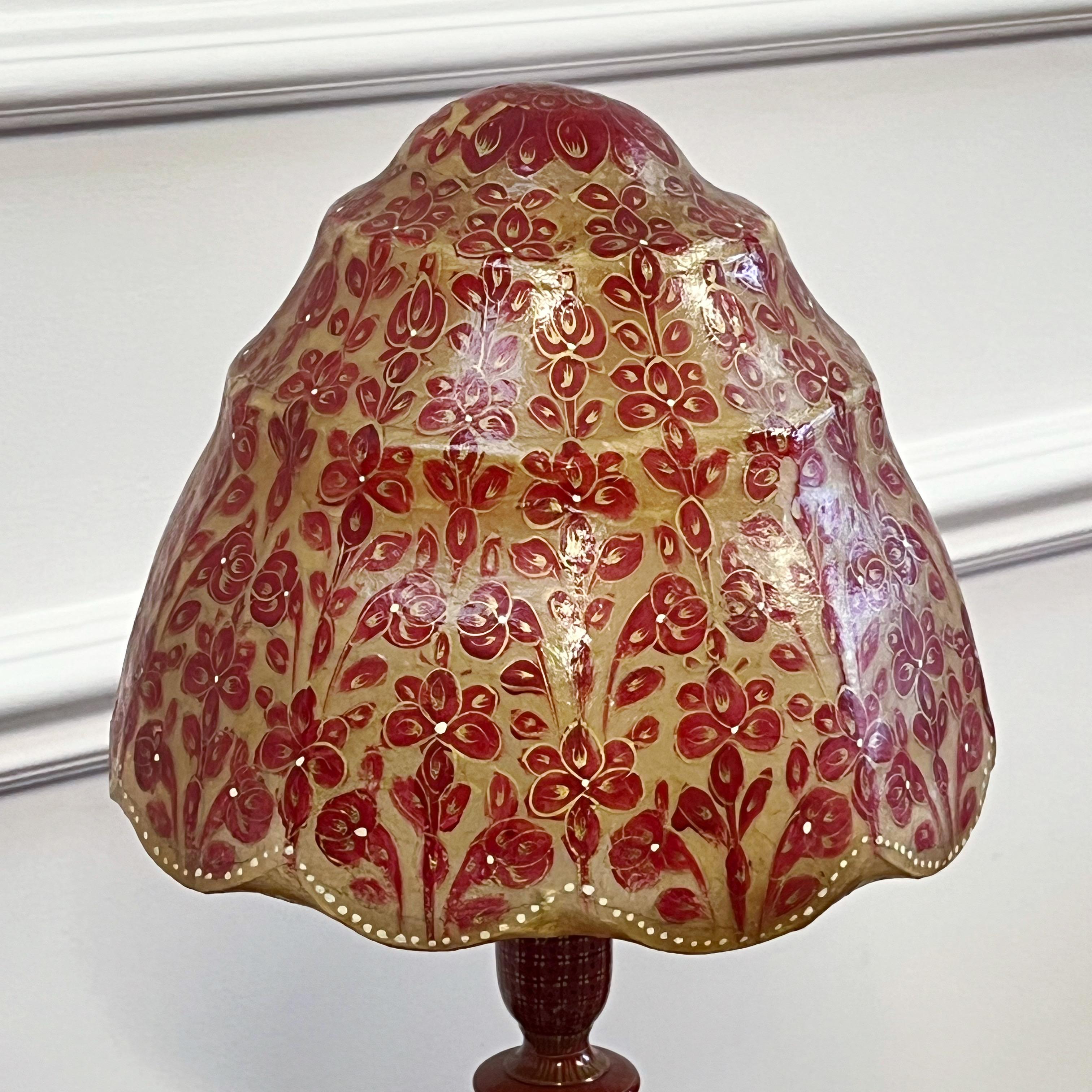 Une lampe inhabituelle en bois tourné et laqué, avec un fond rouge et un décor or et noir, et un impressionnant abat-jour en velum peint à la main, en forme de dôme et à gradins.

Français, début du XXe siècle

H 55 (abat-jour compris) x L 25 cm

