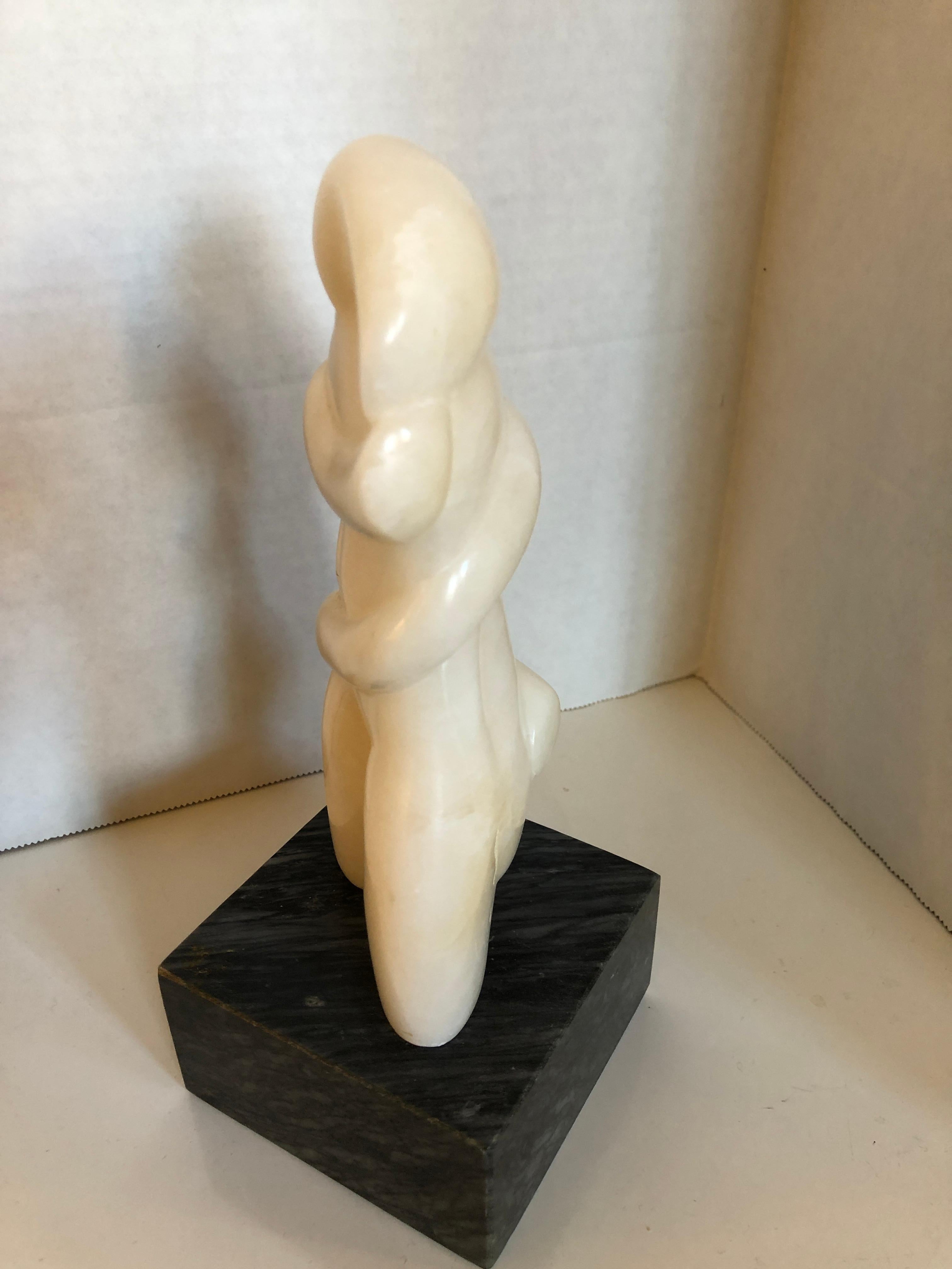 A biomorphic mid twentieth century white marble figural sculpture by Kay Hofmann raised on a black marble base.