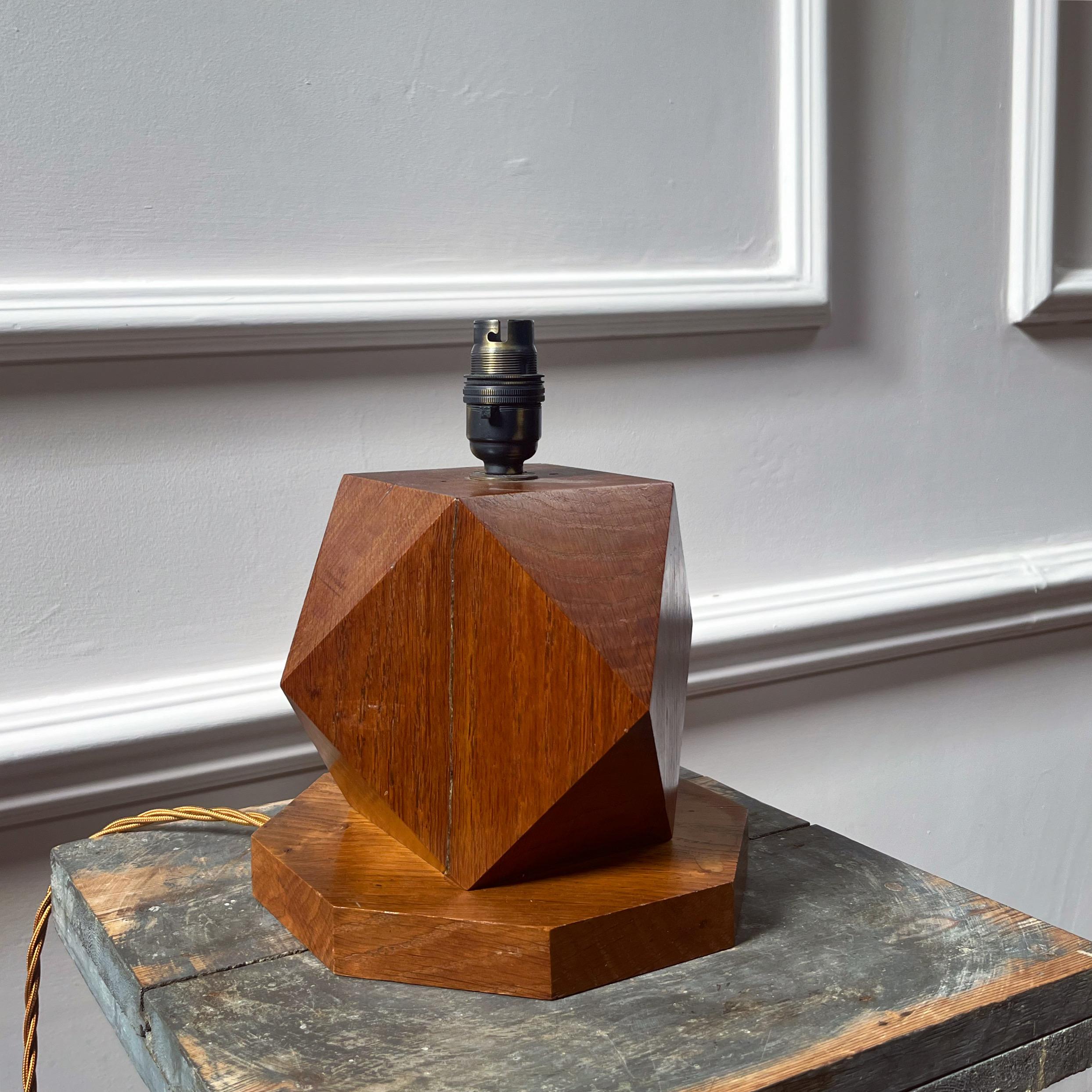 A brutalist oak table lamp, in the form of a tetradecagon on block base.

European, 1950s

H 23 x W 19 cms

