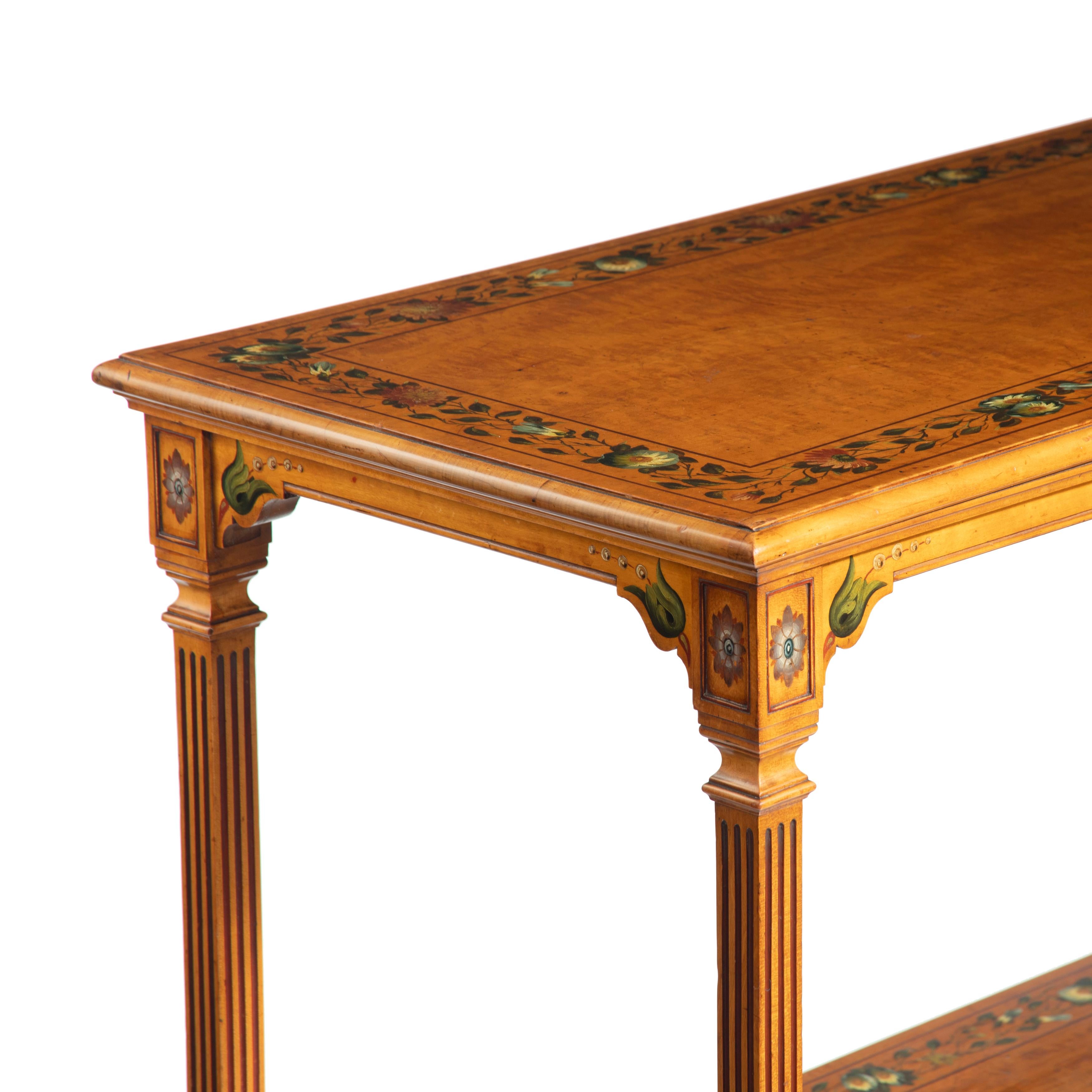 A mid-Victorian free-standing painted satinwood two-tier table, of rectangular form with turned and painted legs, decorated throughout with garlands of flowers, original castors. English, circa 1860.