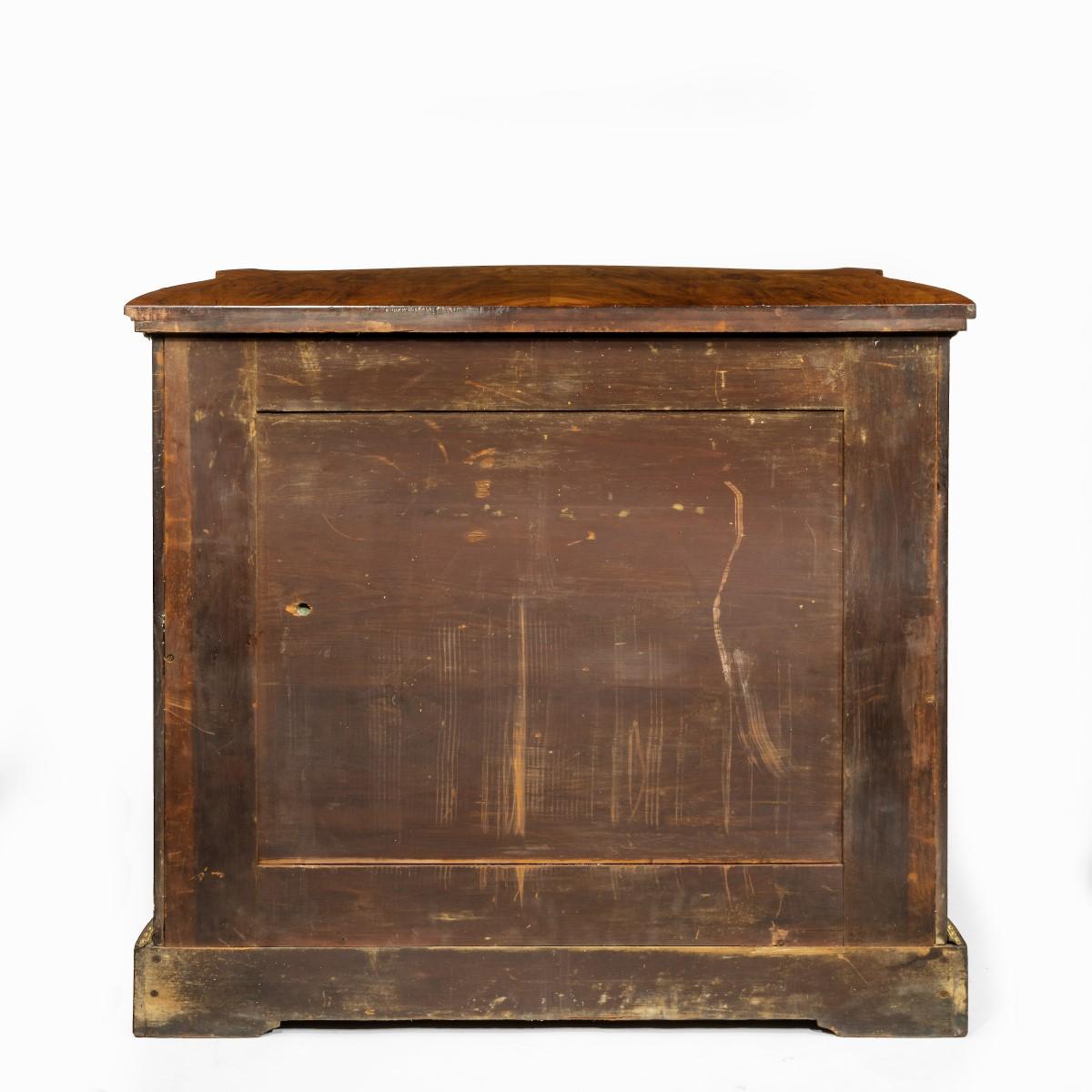 A mid-Victorian kingwood serpentine cabinet, English in the French style, the shaped top with burr-walnut half veneers within kingwood banding and boxwood stringing, the double doors with shaped panels and similar veneers, enclosing a shelf, applied