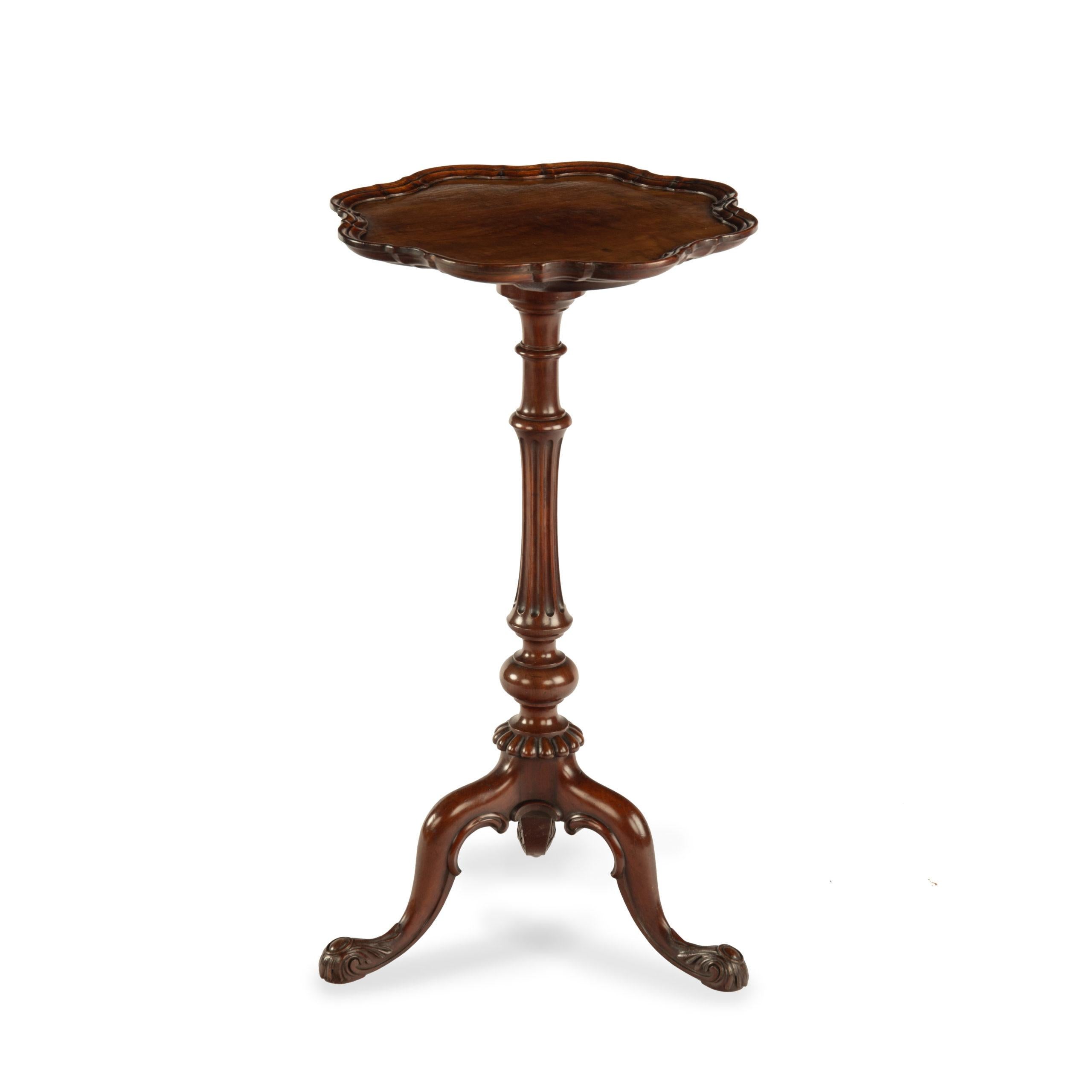 A mid Victorian mahogany wine table attributed to Gillows, the scalloped top set upon a slender turned and fluted support on tripod legs, the feet carved with acanthus leaves.  English, circa 1850.

