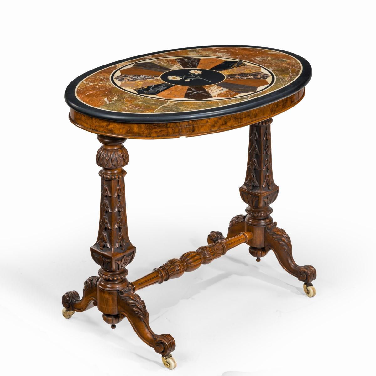 A mid-Victorian walnut and Pietra Dura table, the oval top inlaid in specimen marbles with a roundel of radiating panels centred on a white daisy in on a black ground, all raised on flared square-section supports joined by a turned and gadrooned